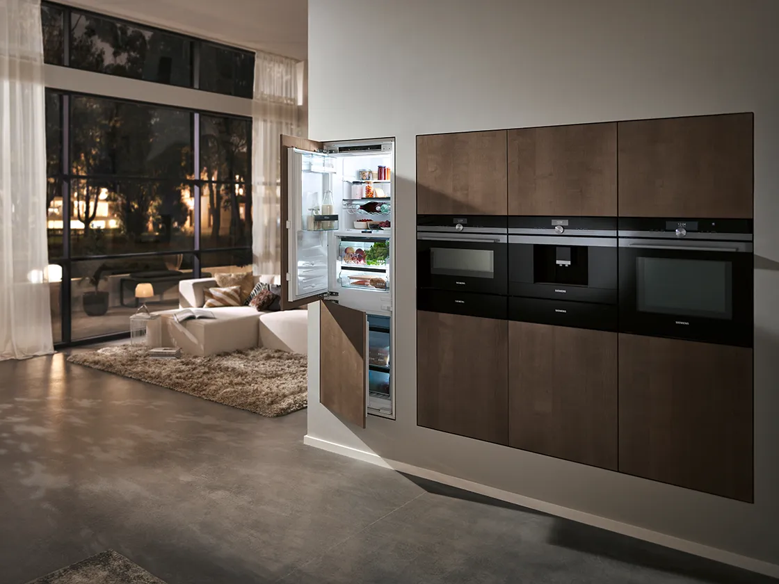 Cozinha moderna com aparelhos elegantes, sala de estar aberta e grandes janelas com vista para o cenário exterior.