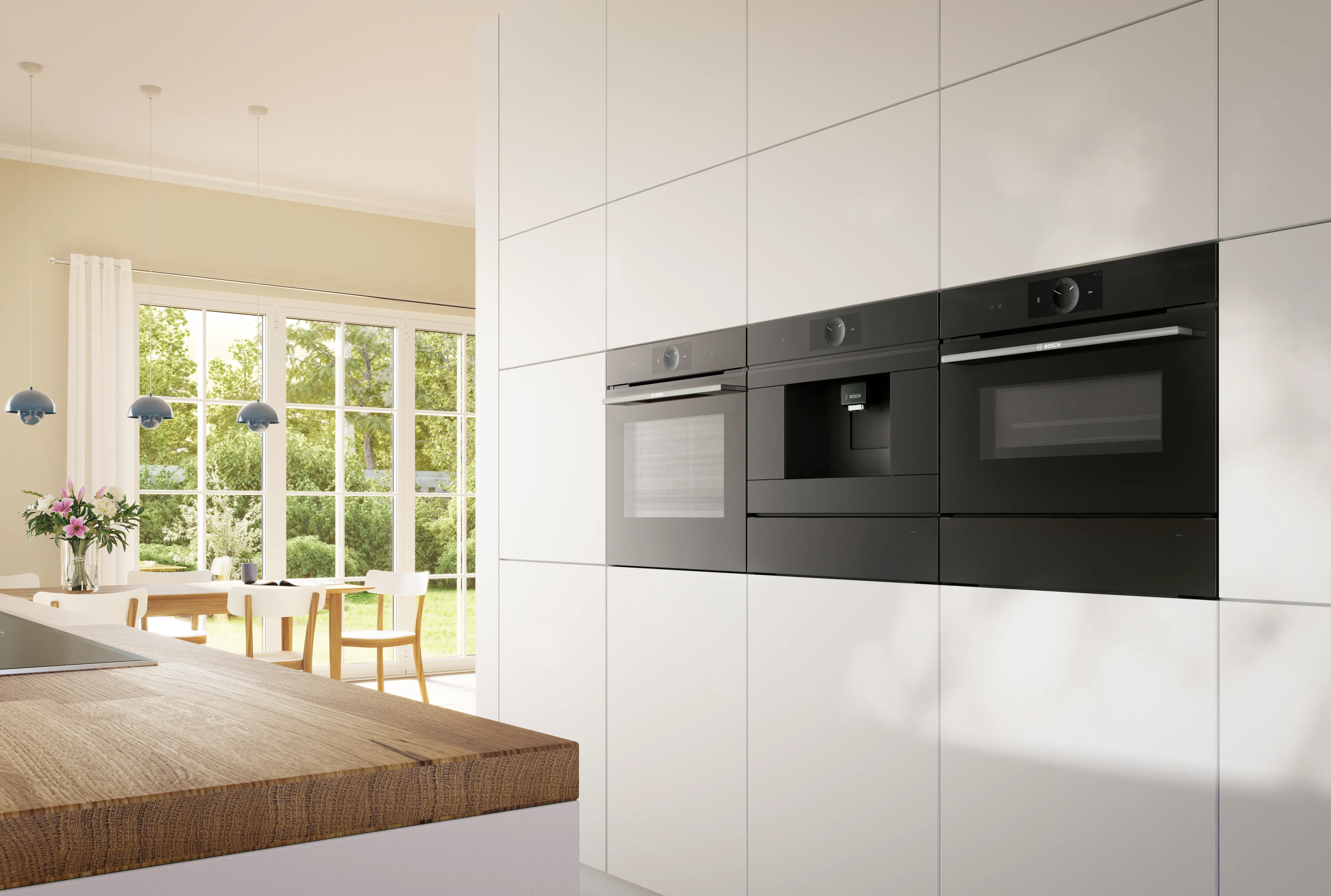 Cucina moderna con grandi finestre, tavolo in legno e elettrodomestici da incasso.