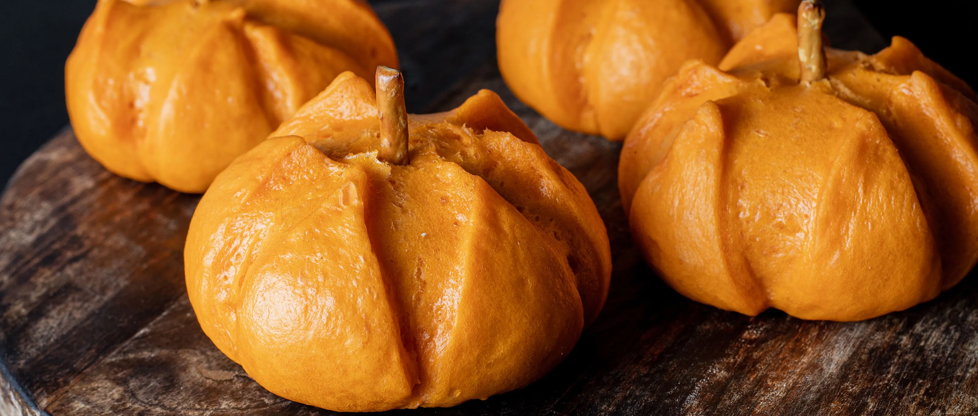 Roasted pumpkins on wooden surface, autumn harvest, seasonal food, orange squash, rustic decor.