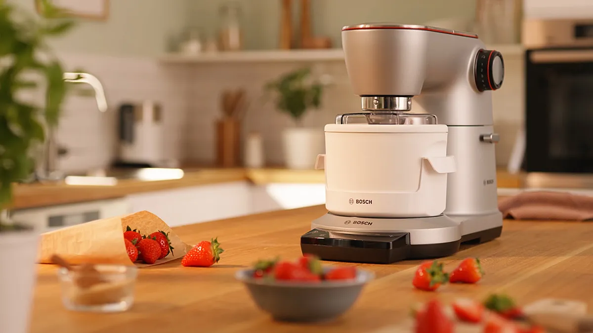 Kitchen counter with Bosch food processor, fresh strawberries, and other kitchen items.