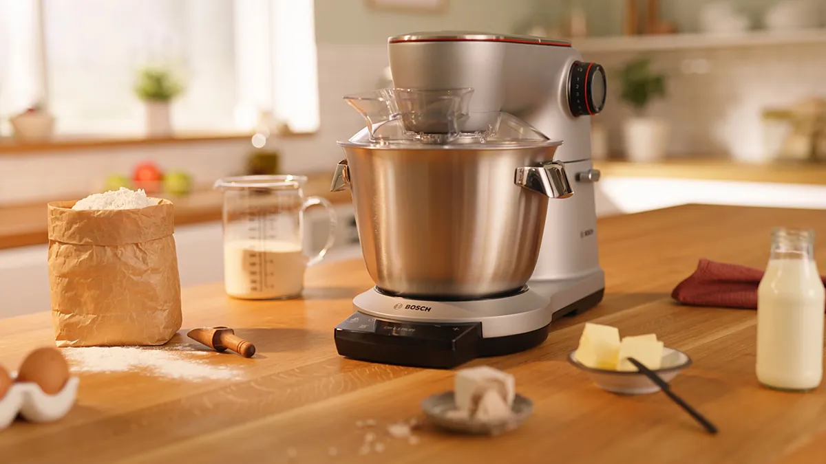 Kitchen counter with baking ingredients, mixer, and other cooking utensils.