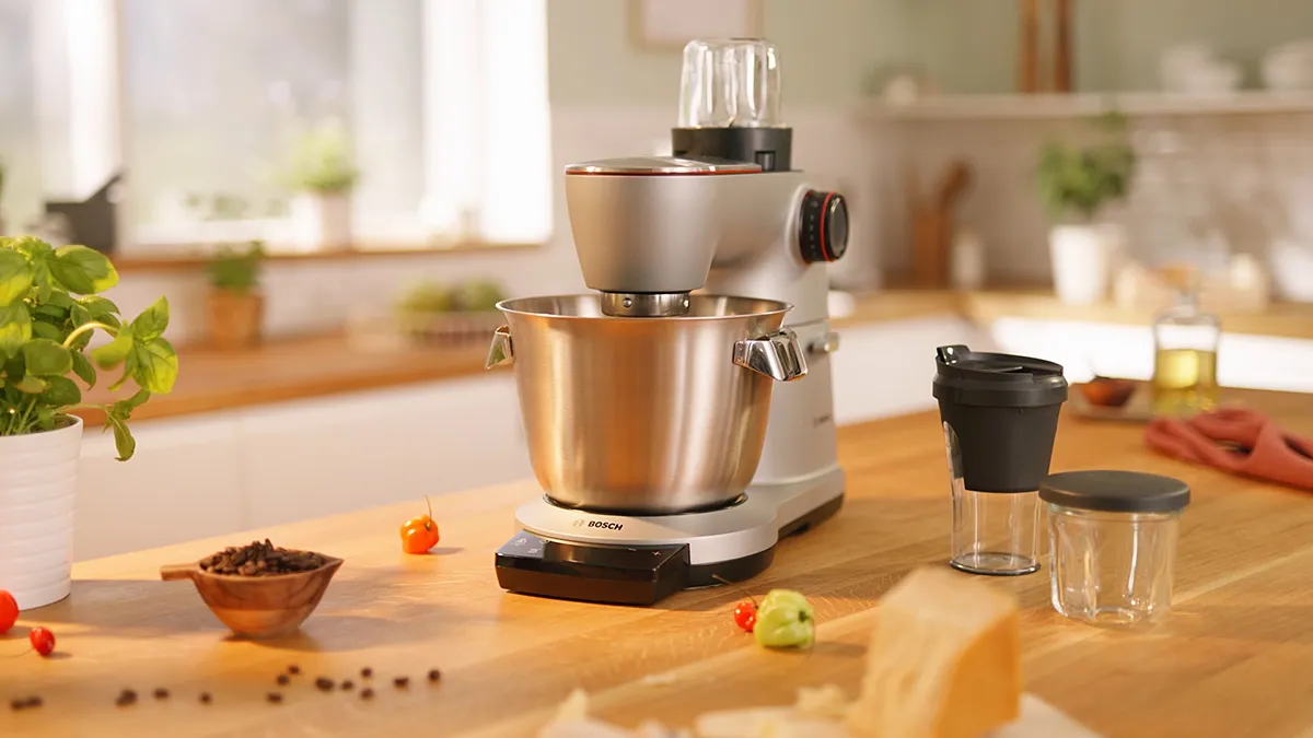 Kitchen appliance, food preparation, stainless steel mixer, vegetables, spices, cooking utensils.