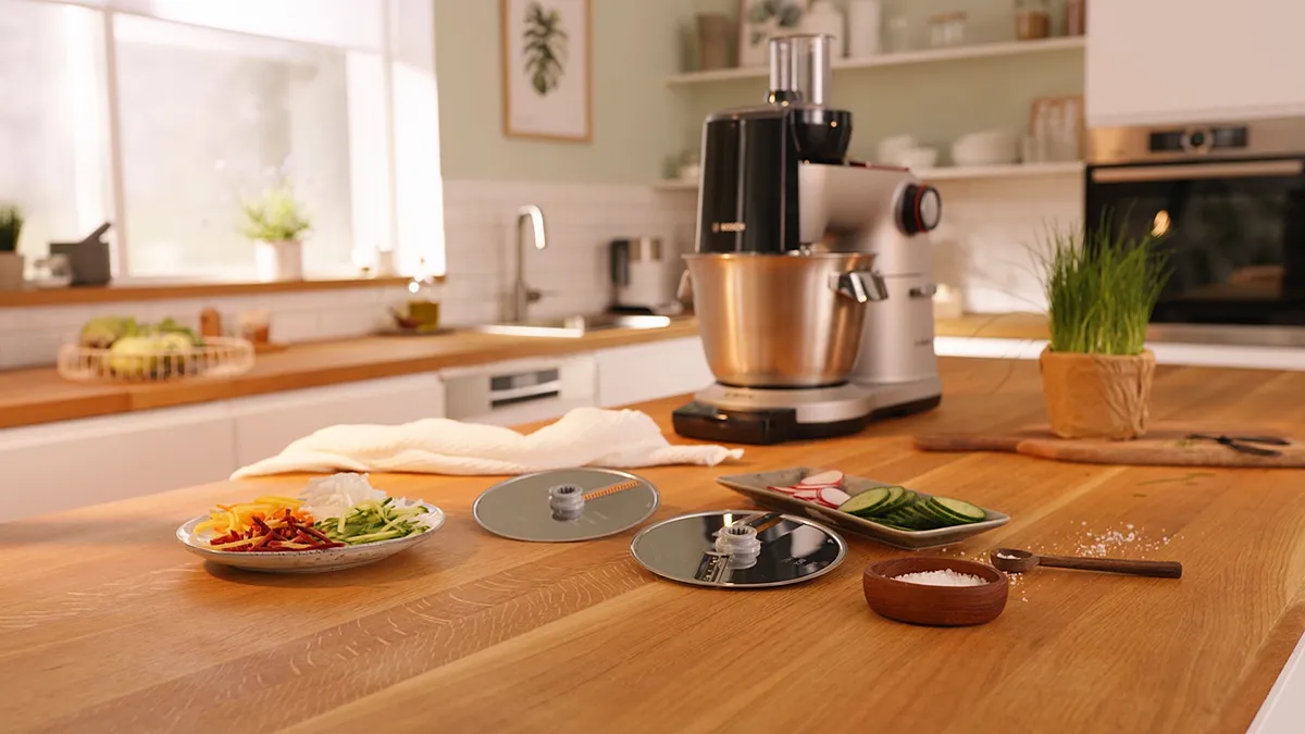 Cozy kitchen with cooking appliances, fresh ingredients, and a wooden table with prepared dishes.