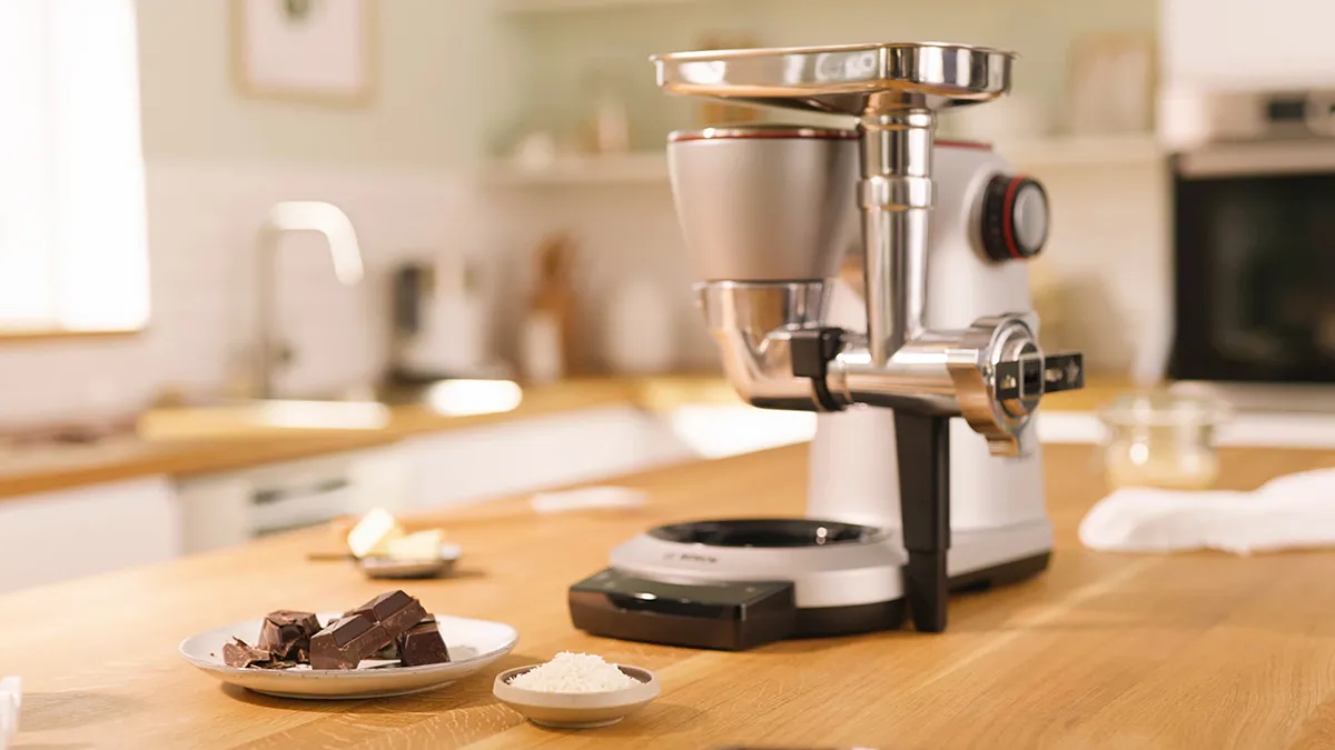 Kitchen counter with coffee grinder, chocolate pieces, and other baking ingredients.