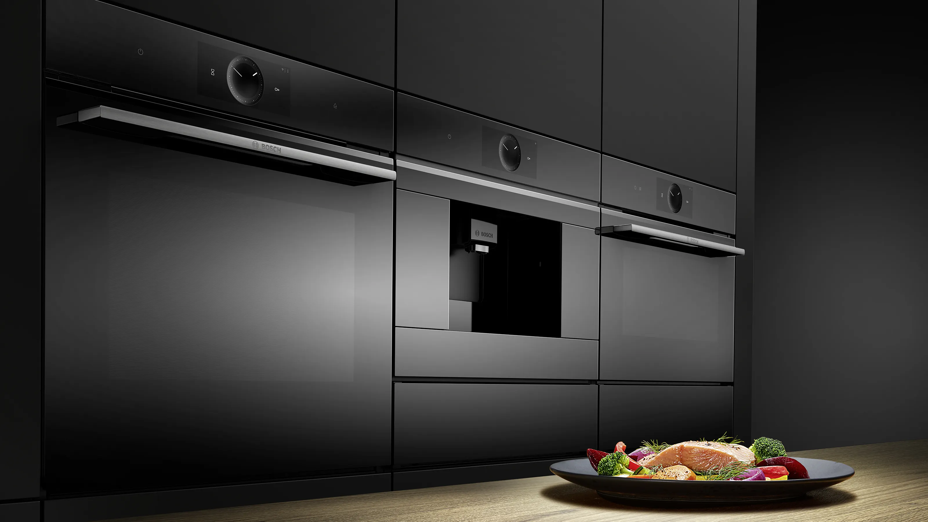 Forni da incasso Bosch Serie 8 dal design nero elegante, integrati in una cucina moderna con macchina da caffè da incasso e comandi digitali avanzati.