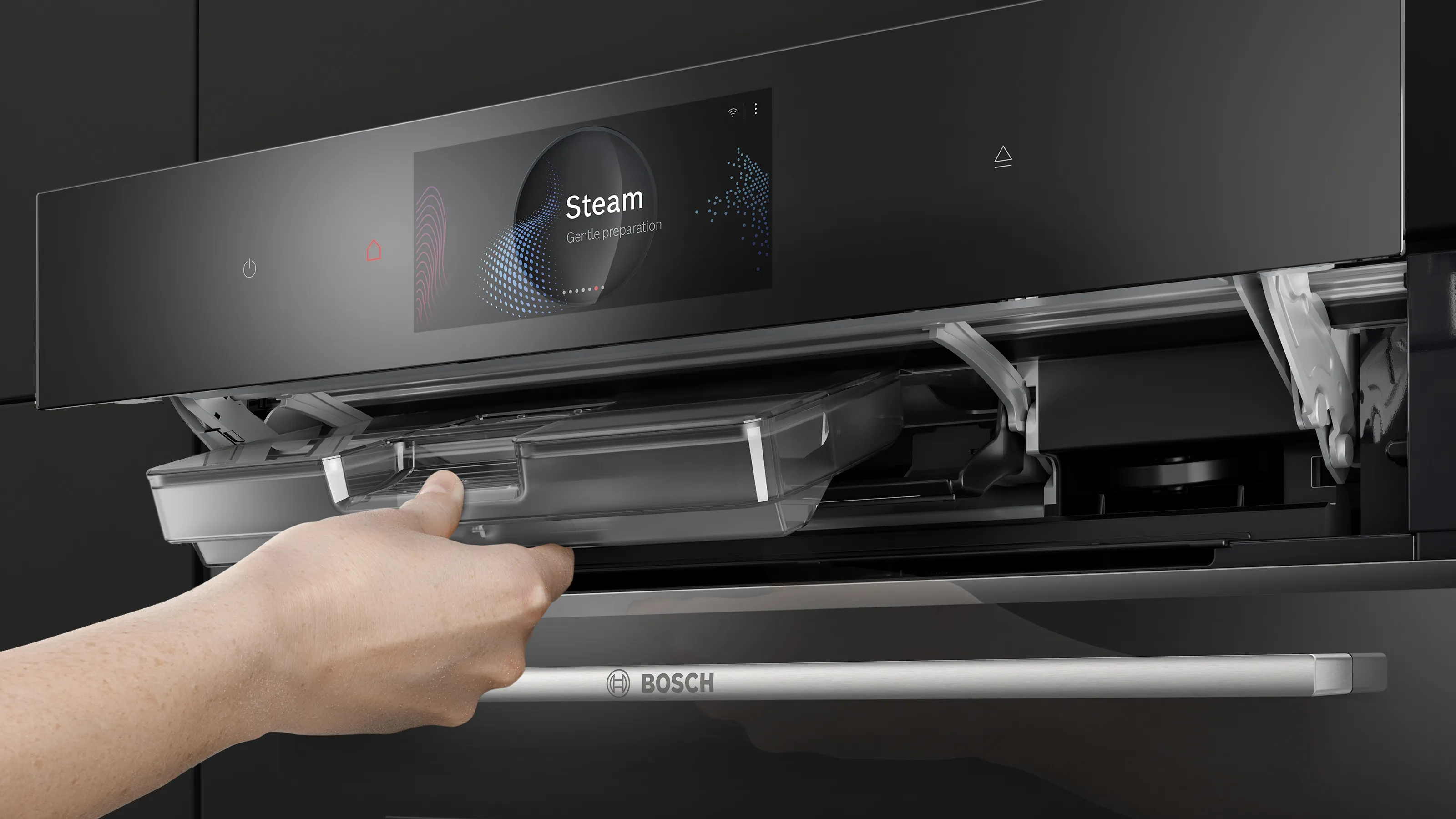 Series 8 oven. A person pulls out the water tank, which is located behind the flipped-open display.