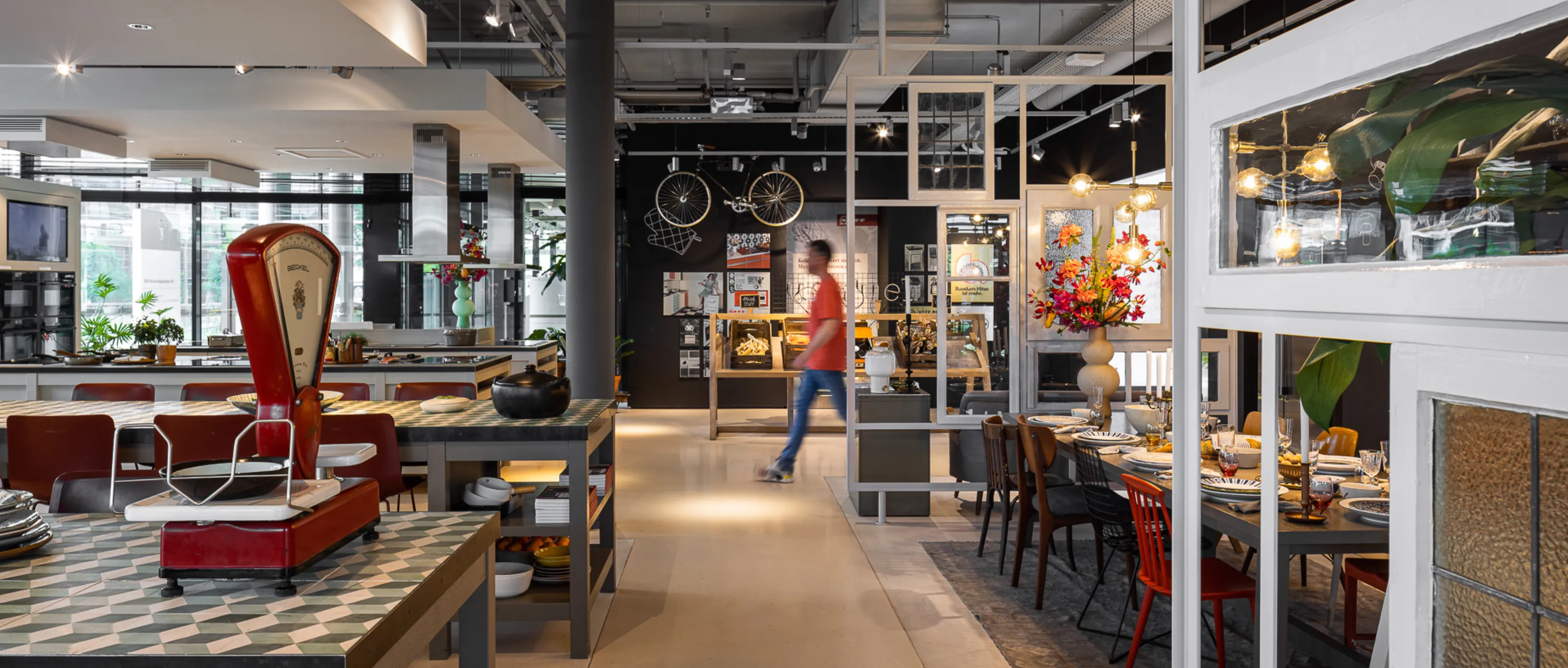 Ruim modern cafe interieur met industriële inrichting, zithoeken, en klanten.