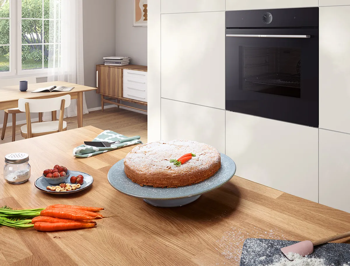 A perfectly baked cake on a kitchen counter with a modern kitchen in the background.