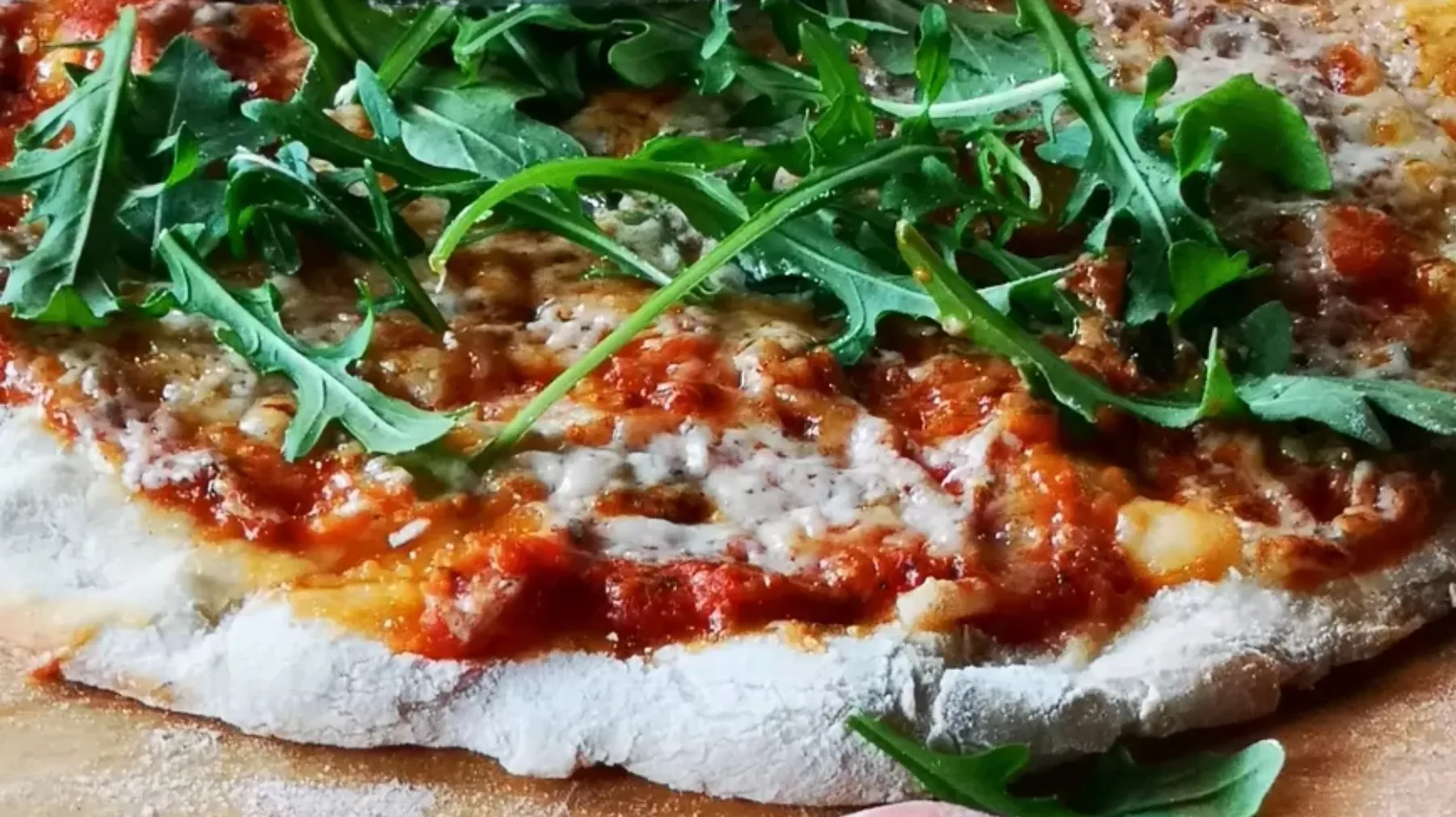 Frisch gebackene Pizza mit Käse und Rucola