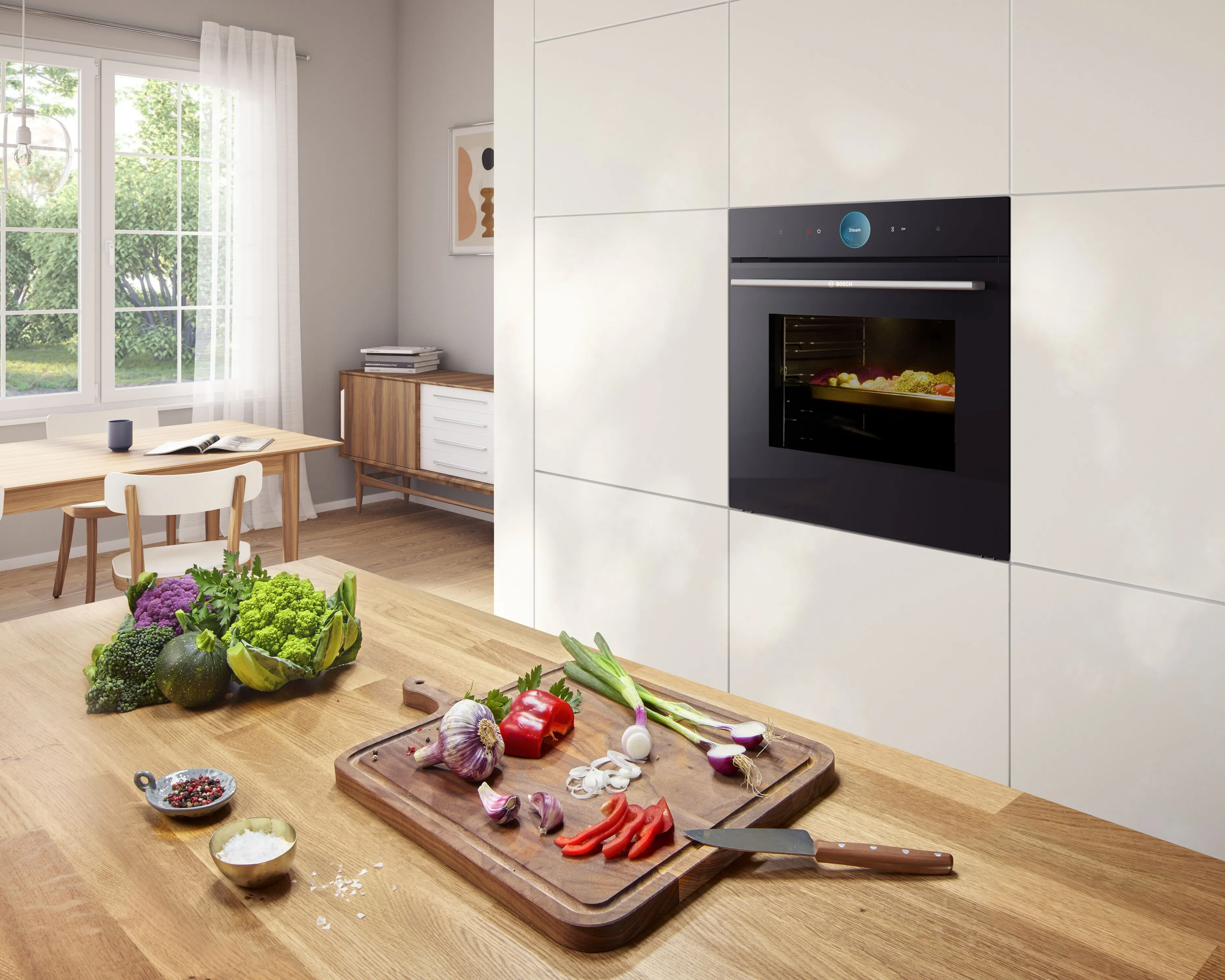 Modern kitchen with vegetables on a wooden cutting board, fresh greens, and a built-in oven baking food.