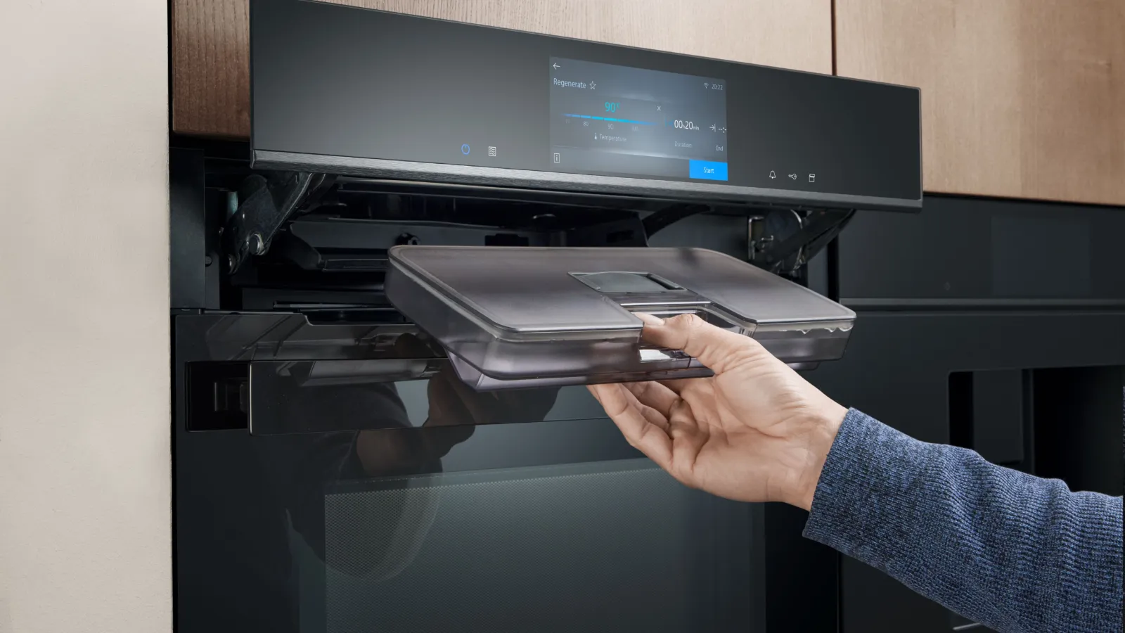 Een persoon voegt water aan een Siemens oven toe om te kunnen stomen.