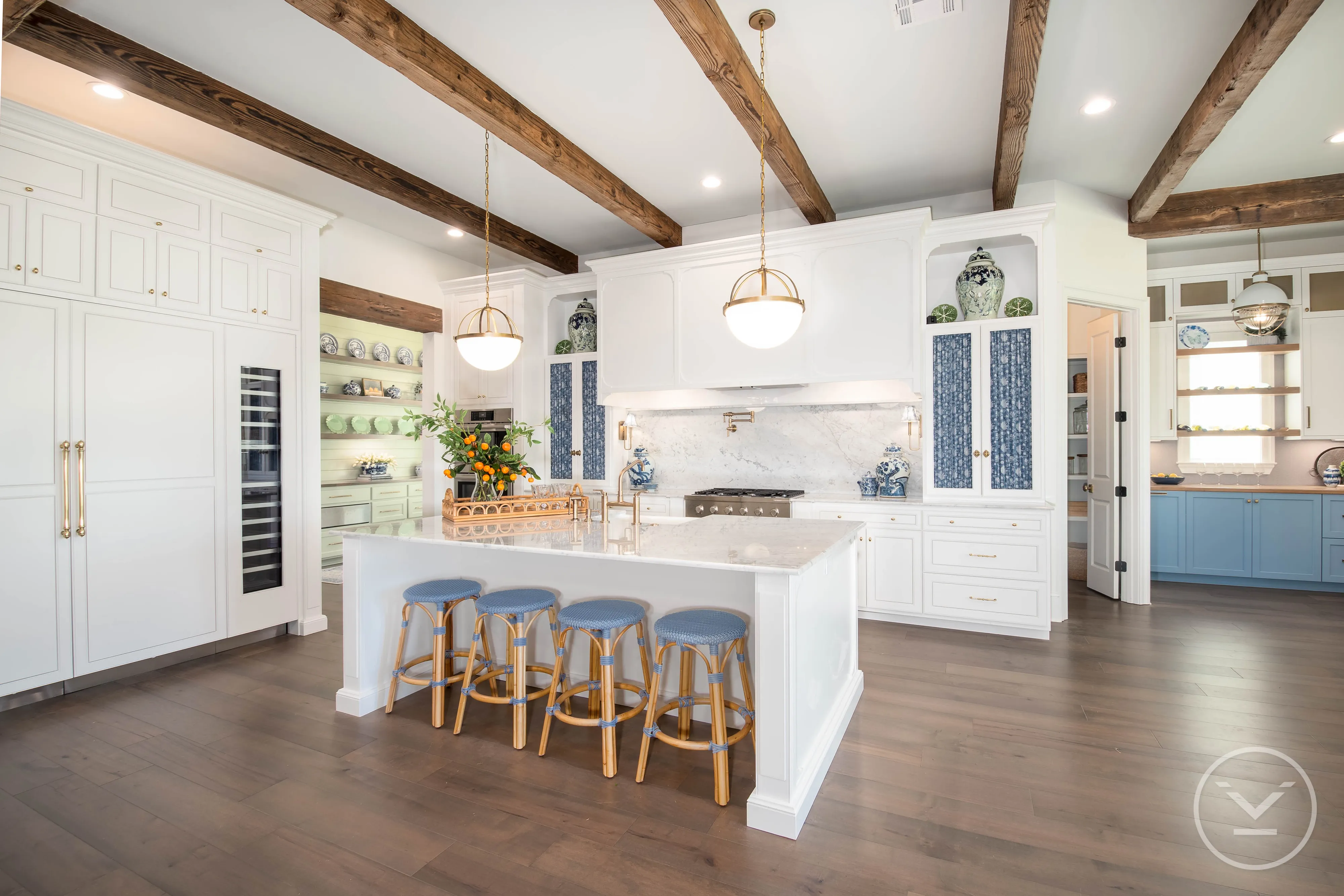 Modern kitchen with island, bar stools, exposed beams, and pendant lights.