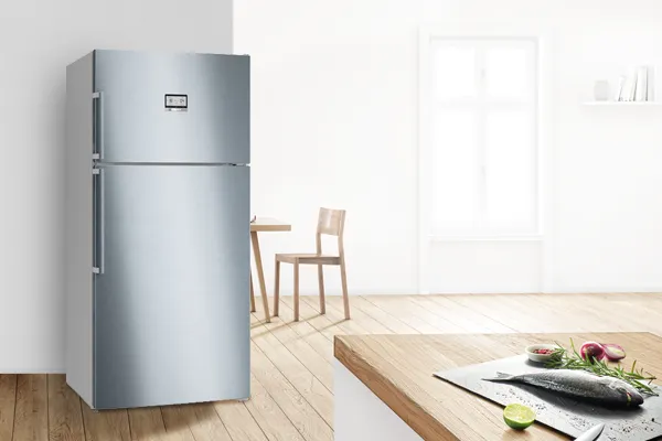 Modern mutfakta ahşap zemin, sandalye ve yeni ürünlerle büyük gümüş buzdolabı.