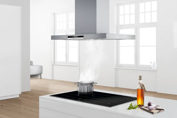 Beyaz duvarlarla modern mutfak, ahşap zemin, ocak ve yemek aletleri.