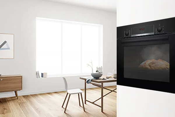 Modern mutfak ahşap masa, sandalyeler ve siyah fırın ile iç.