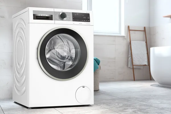 Modern beyaz çamaşır makinesi parlak, minimalist banyo iç.