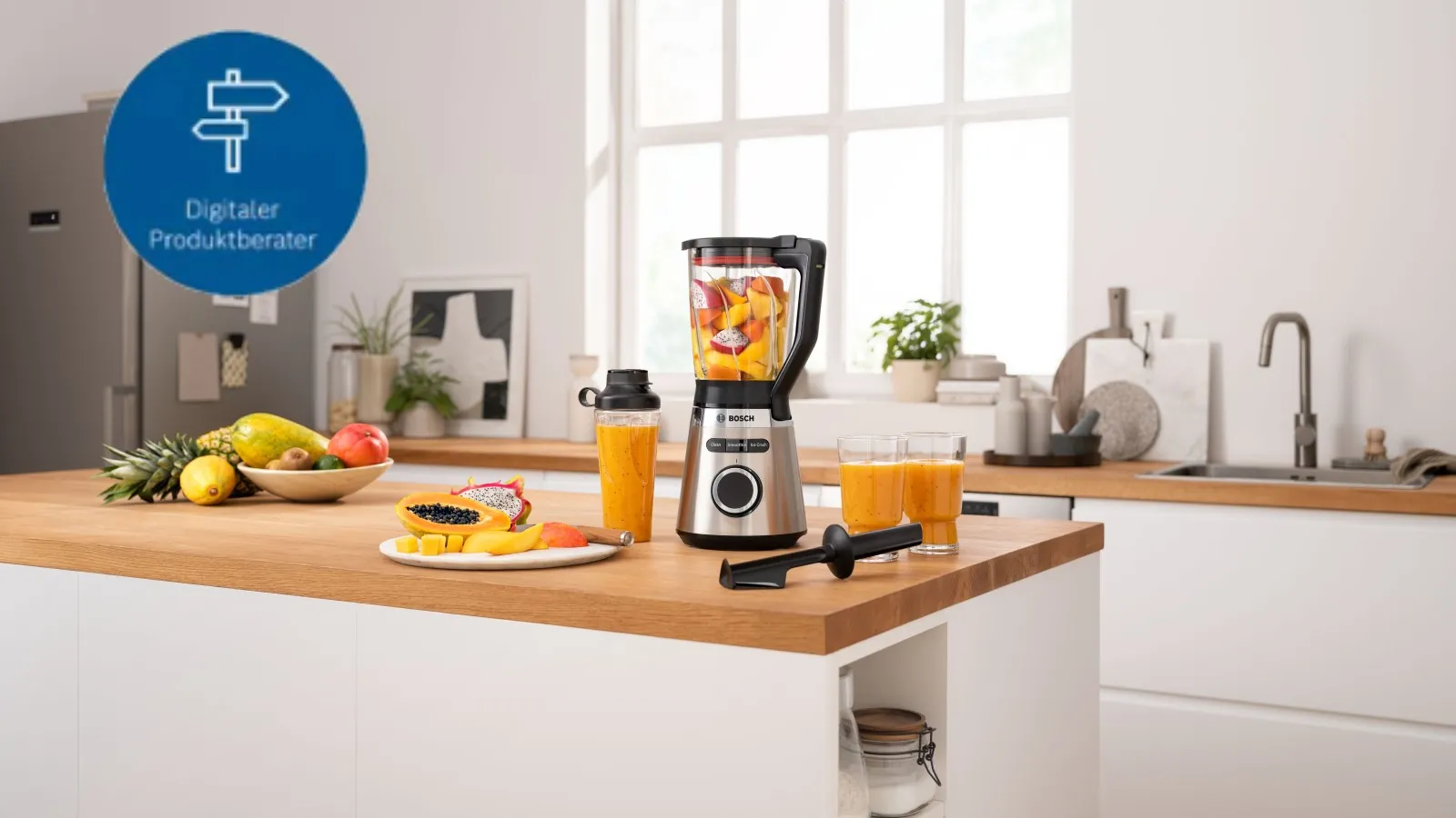 Moderne Küche mit einem Mixer voller Früchte, frischen Saftgläsern und einer bunten Fruchtschale auf einer Holzarbeitsplatte.