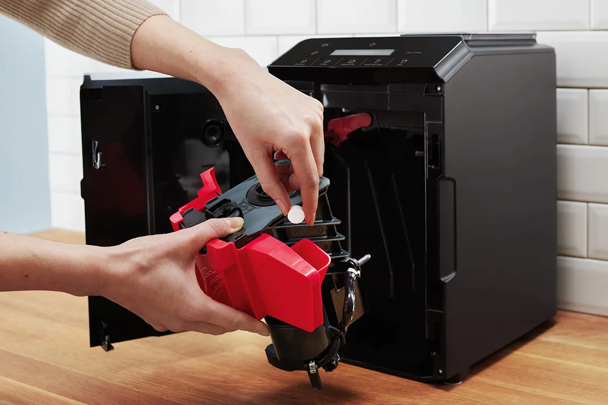 Someone putting something inside Bosch 500 Series VeroCafe espresso machine