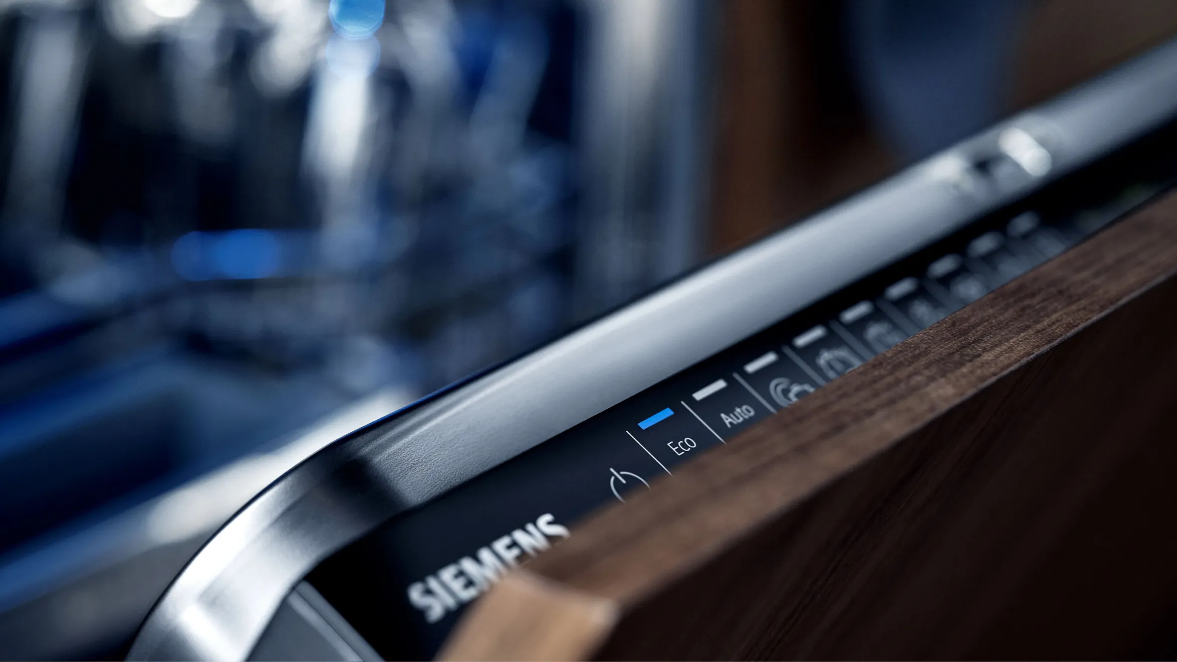 Closeup of a Siemens appliance control panel with buttons and knobs on a wooden surface.