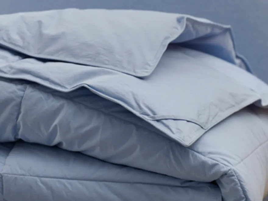 Crumpled gray bedding, soft and inviting, creating a cozy and relaxing atmosphere.