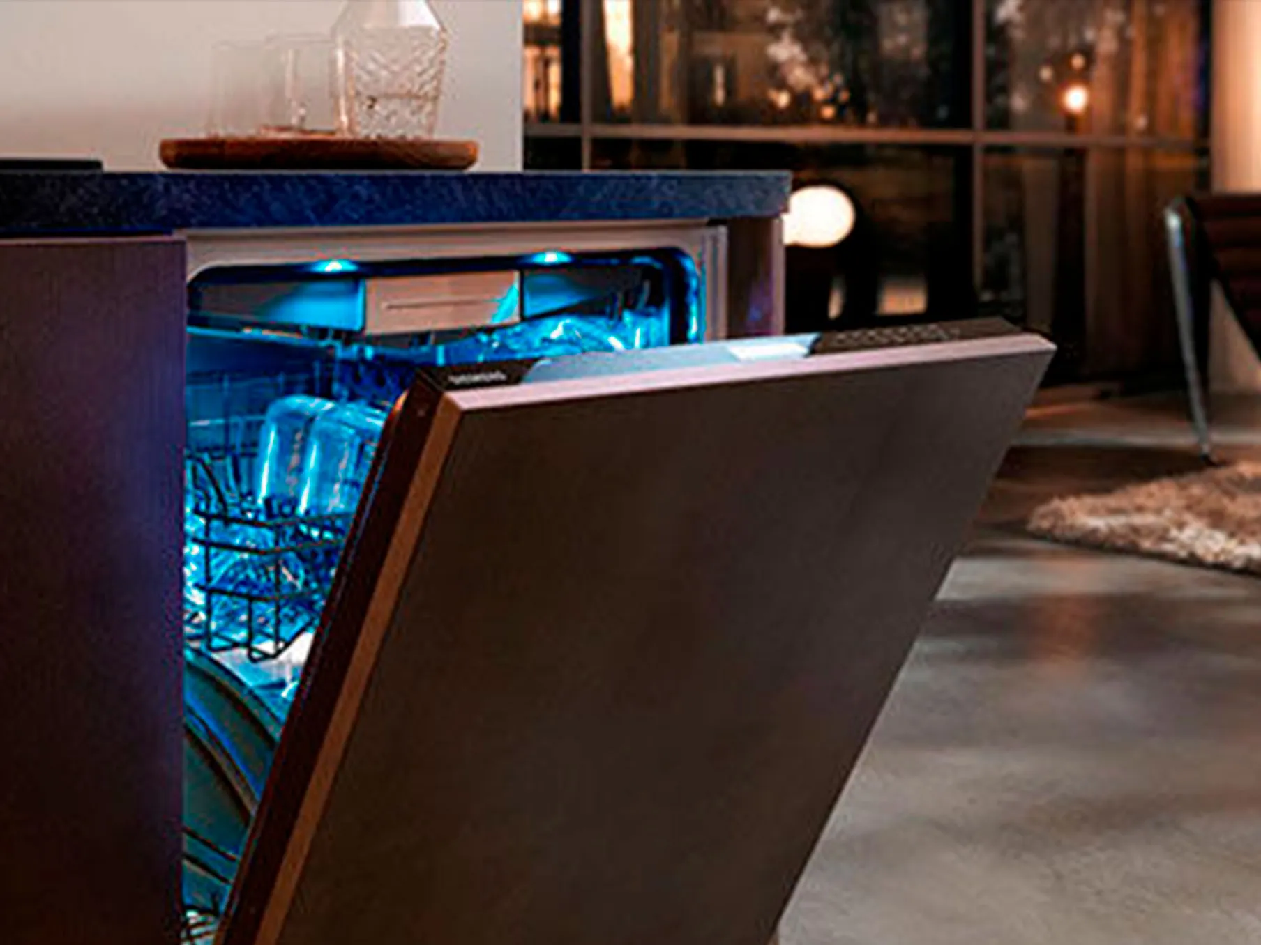 Dishwasher med glödande blå inredning, öppen dörr, glasögon och rätter synliga.