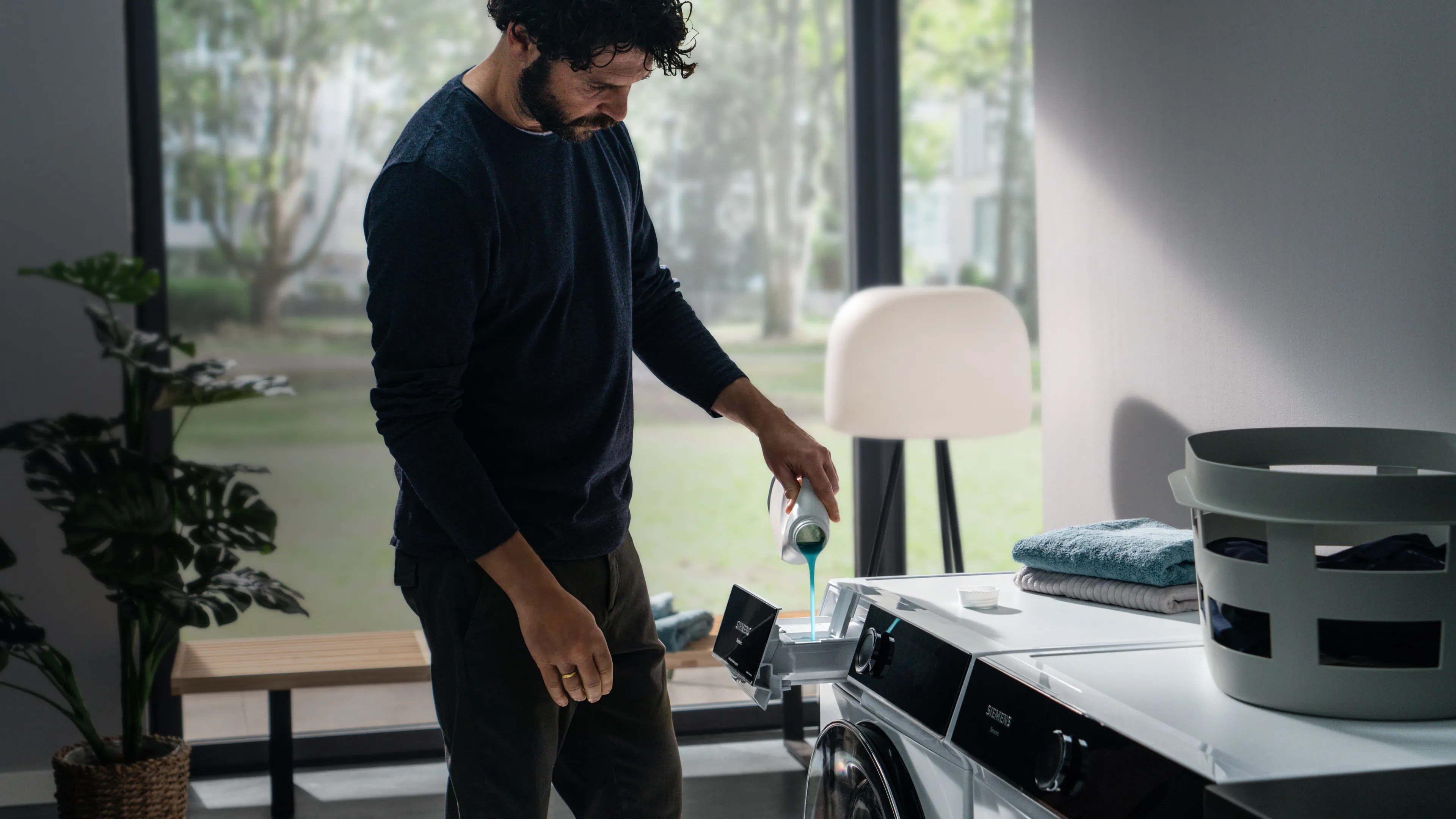 Man pouring detergent into washing machine