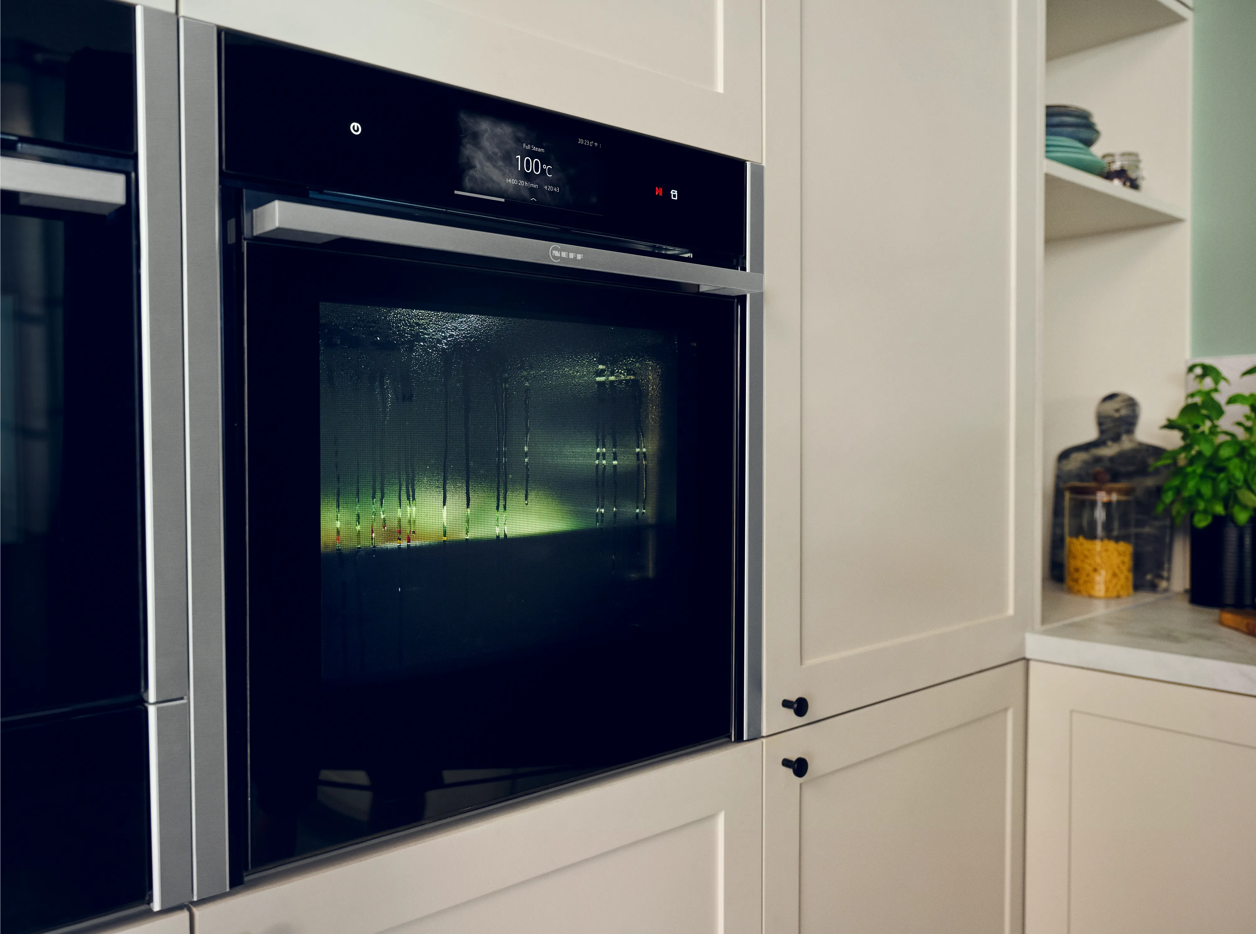 Moderne Küche Ofen mit Digital-Display, Regale und Topfpflanze im Hintergrund.