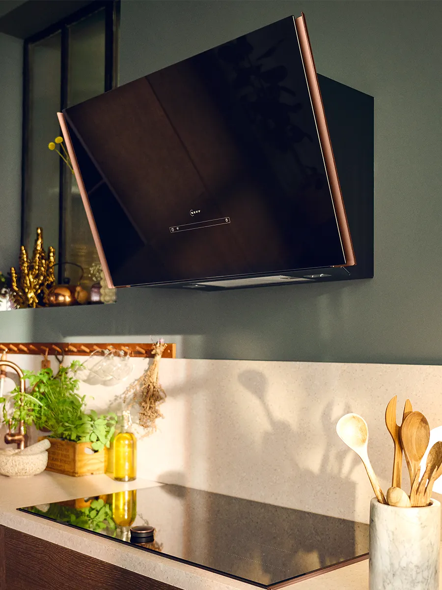 Een diagonale wandschouwkap met Flex Design aan een groene muur in een lichte keuken.