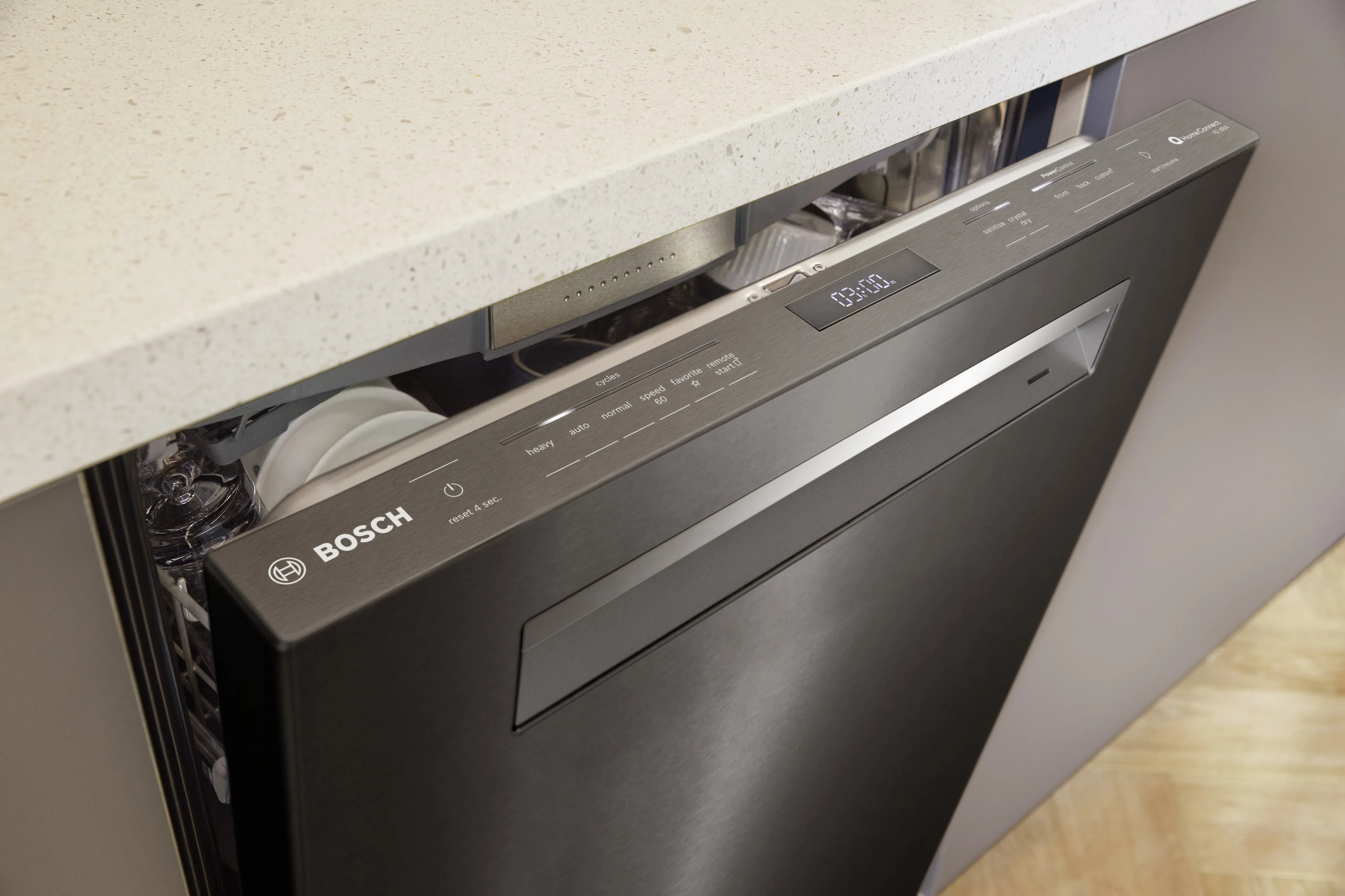 Black Bosch dishwasher partially open with visible control panel and countertop above.