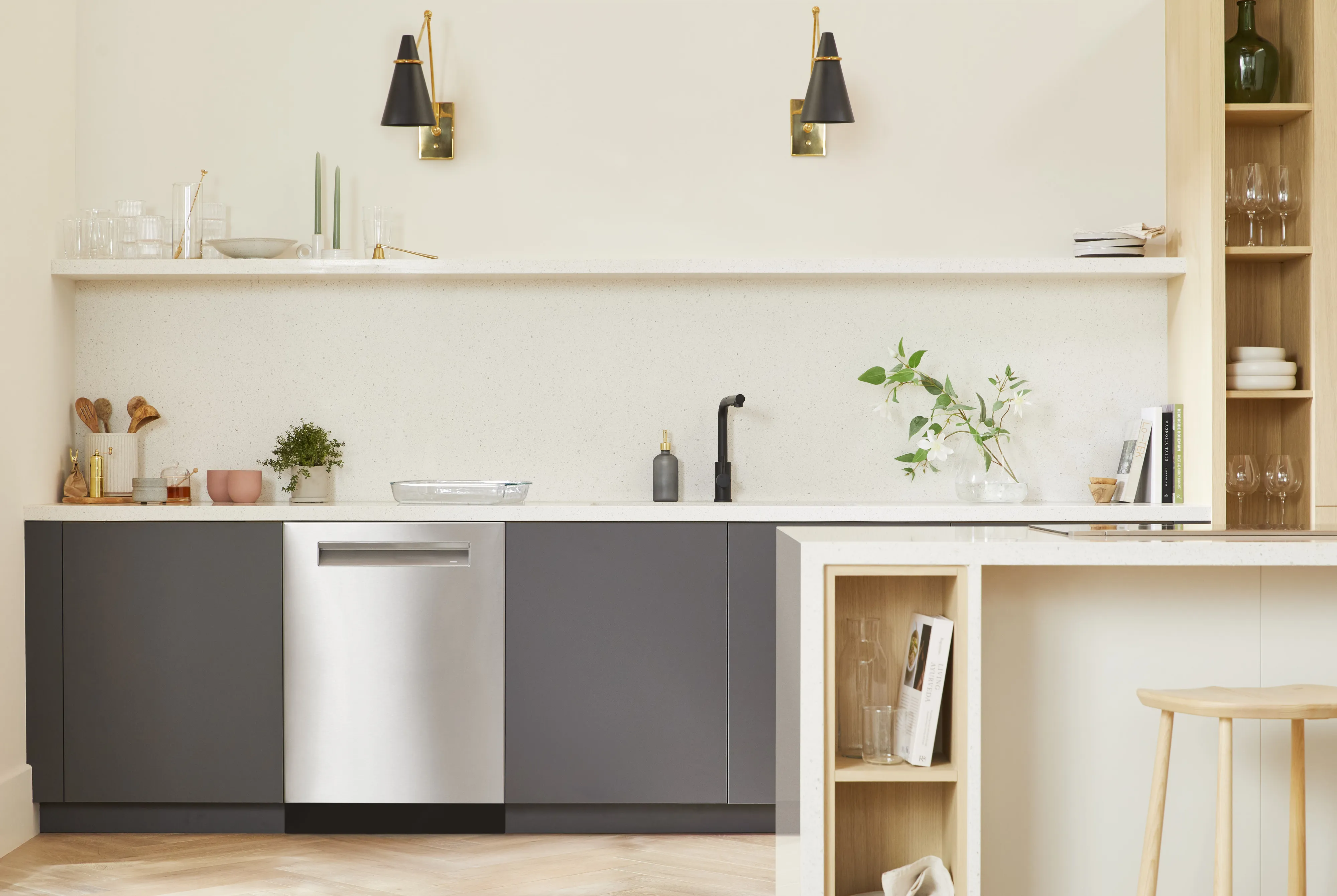 Bosch 24" dishwasher next to dark grey cabinets inside a bright color kitchen