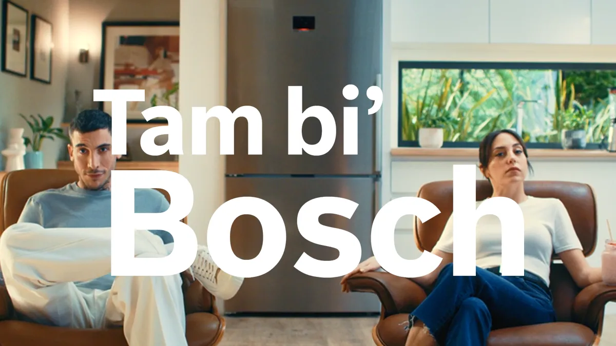 Bir oturma odasında sandalyelerde oturan iki kişi, metin "Iam bi Bosch" belirgin bir şekilde gösteriliyor.