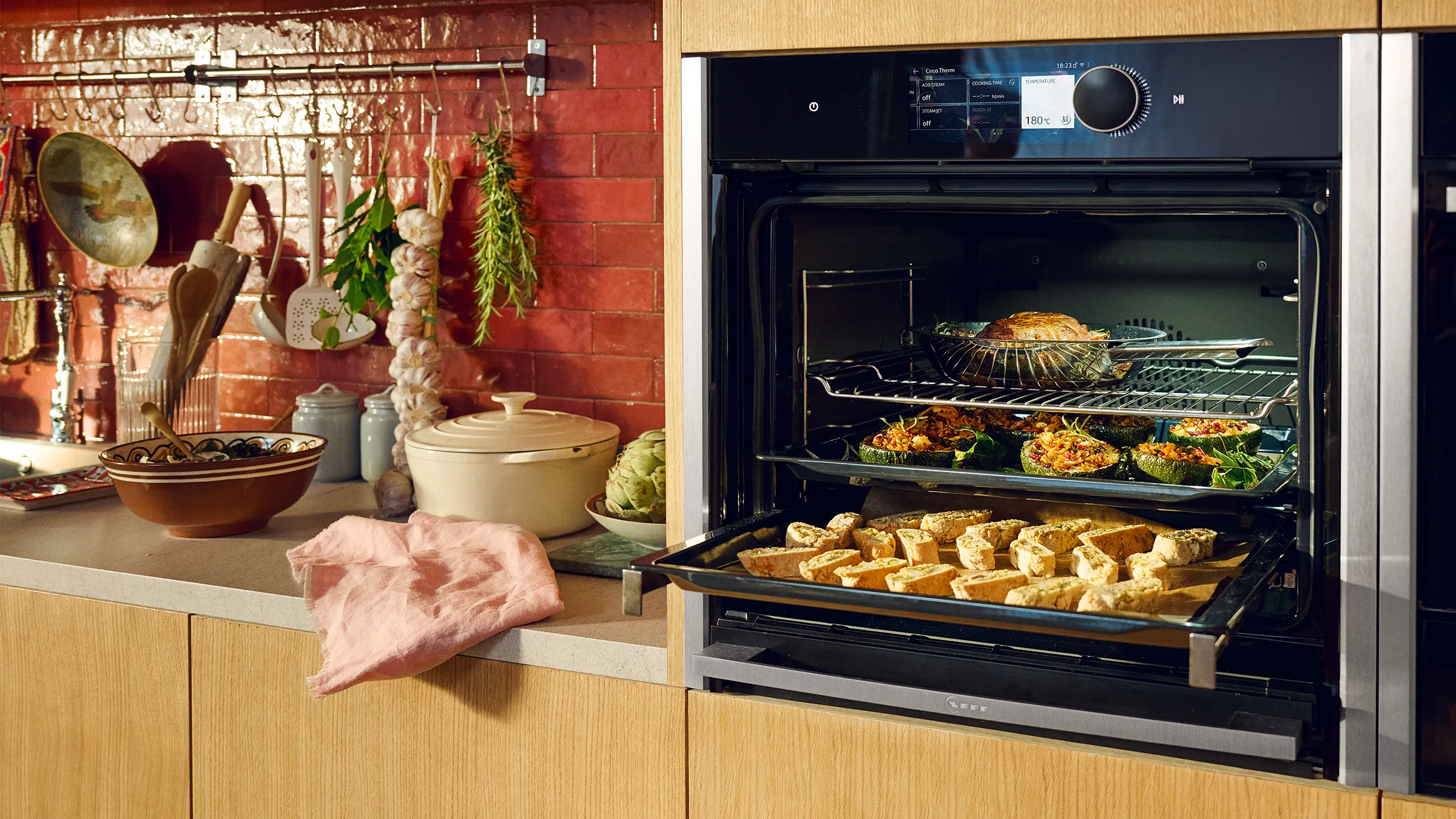Cozy kitchen with baked goods in oven, fresh produce, and cooking utensils on counter.