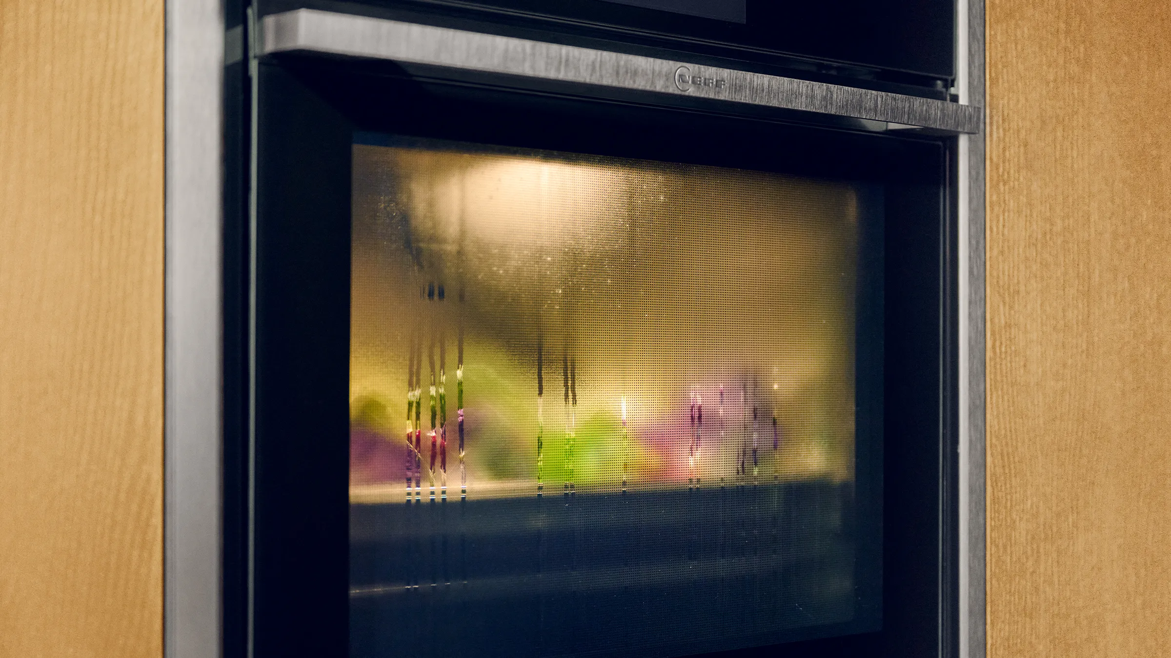 Close-up of a steam oven with a touchscreen panel displaying options for heating, meals, and cleaning.