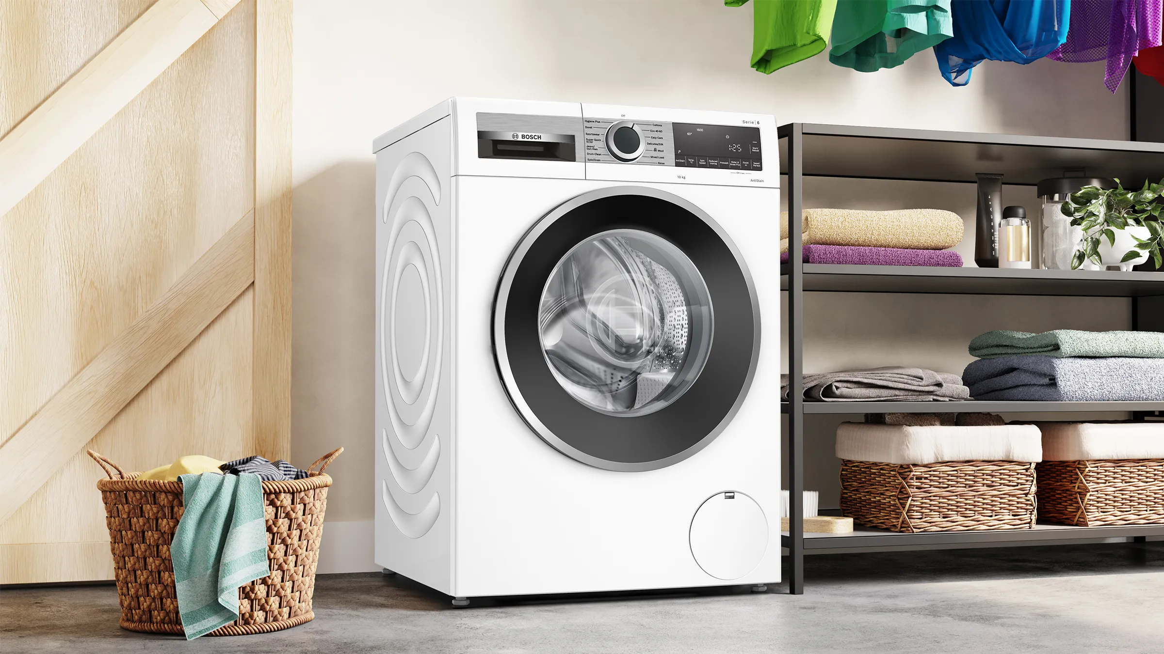 Washing machine, laundry baskets, shelves with towels and clothes, wooden wall, modern appliance.