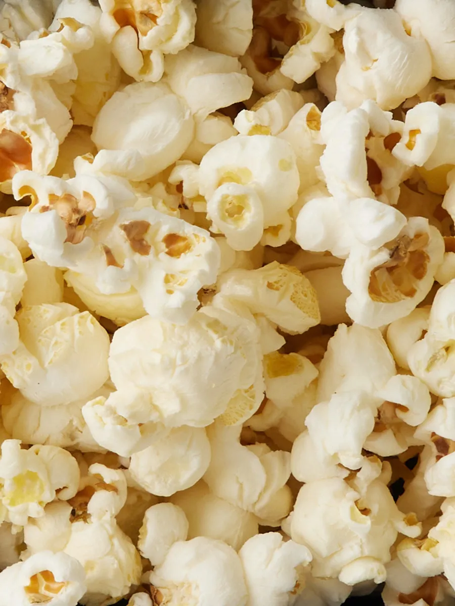 Closeup of freshly popped popcorn kernels, with a golden, buttery appearance.