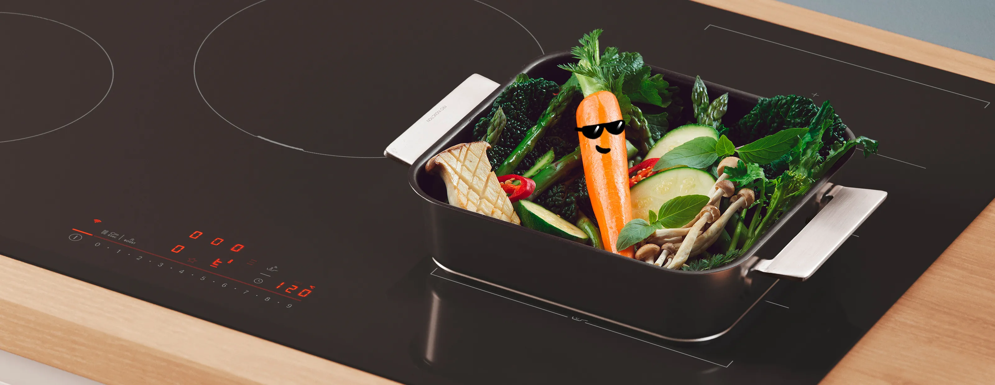 Vegetables in a black container on a glass-top stove, including a carrot with sunglasses.