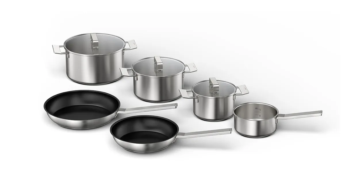 Stainless steel cookware set with pots, pans, and lids on a white background.
