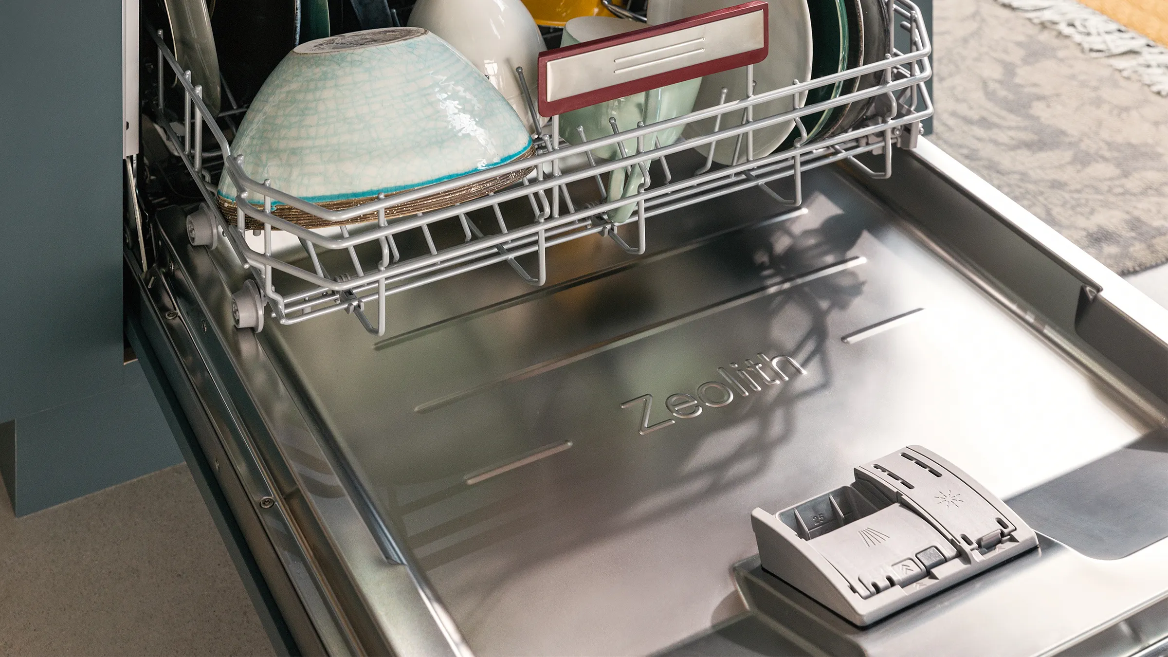 Open dishwasher door showing zeolith drying