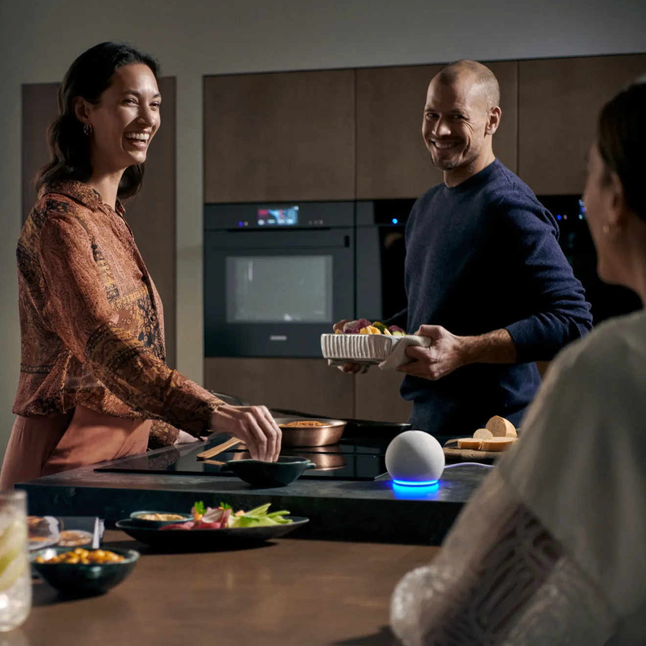 Couple cooking together in kitchen, smiling, preparing food on counter.