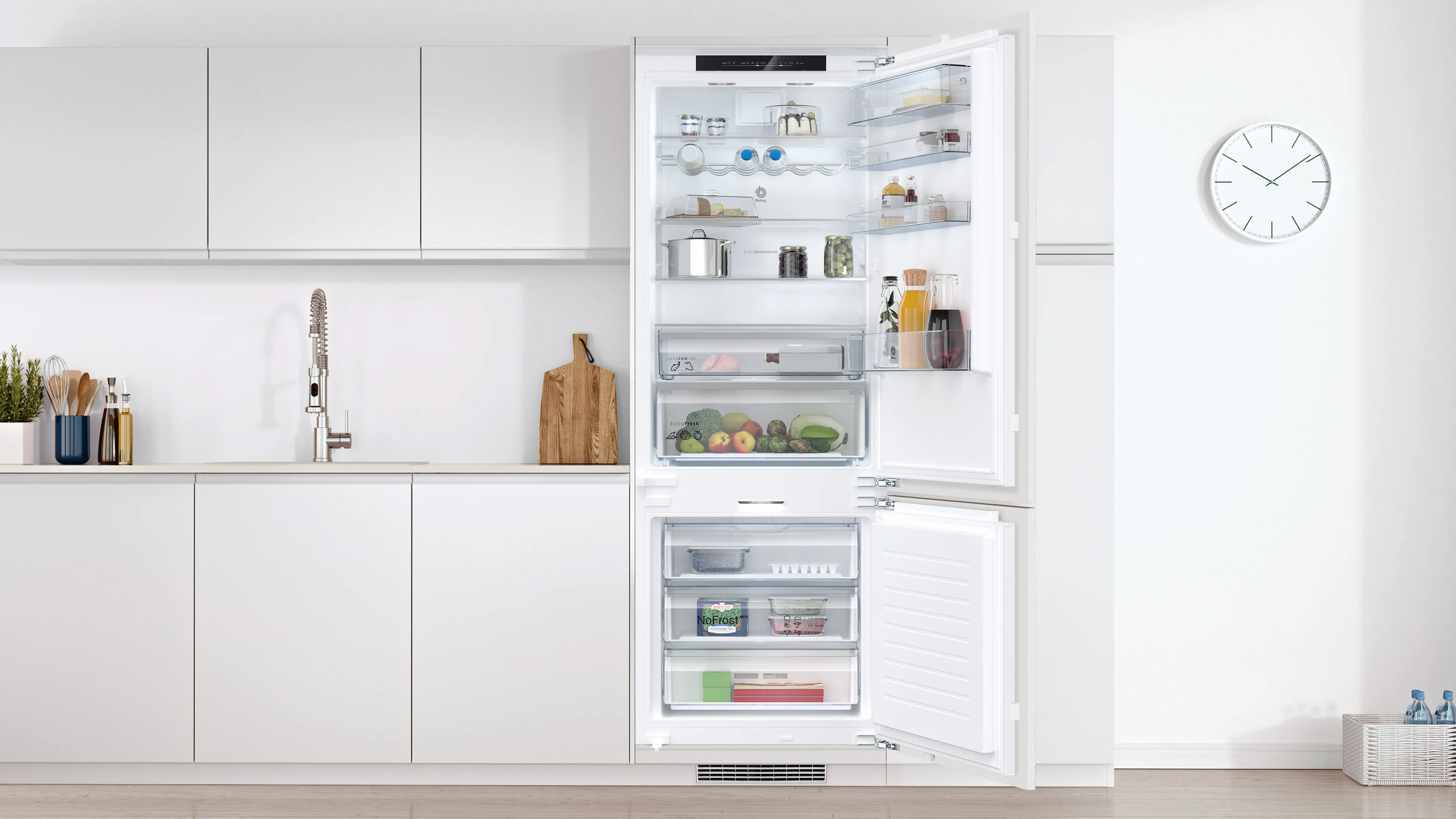Cocina moderna con refrigerador abierto que exhibe diversos alimentos y accesorios de cocina.
