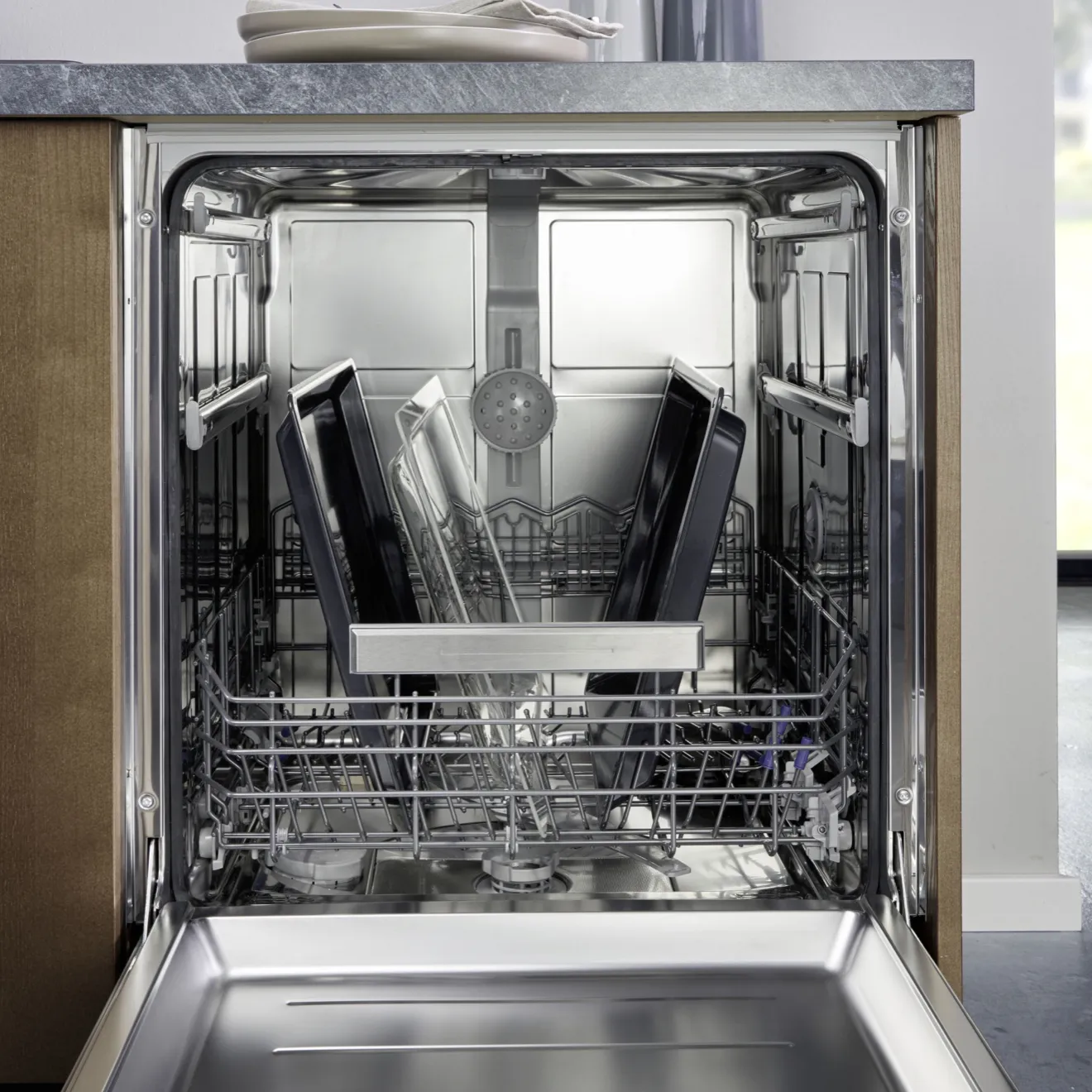 Open dishwasher with clean dishes and glassware inside.