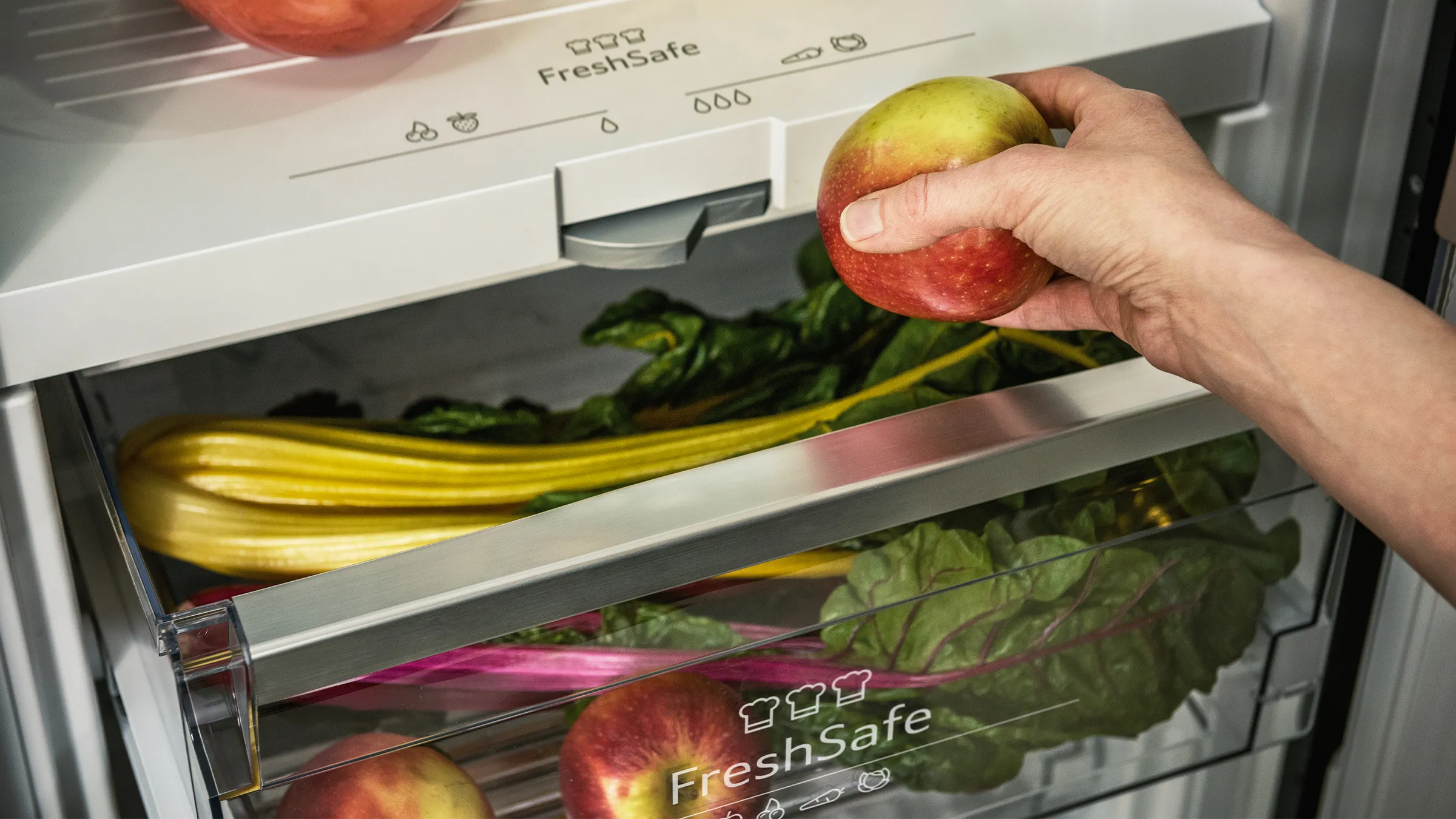 Person putting fruit and veg in fresh safe fridge drawer