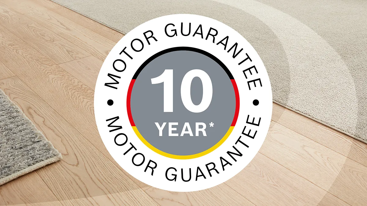 A teaser saying "10-year motor guarantee" and featuring the colours of the German flag is superimposed on a shot of carpet and wooden flooring.