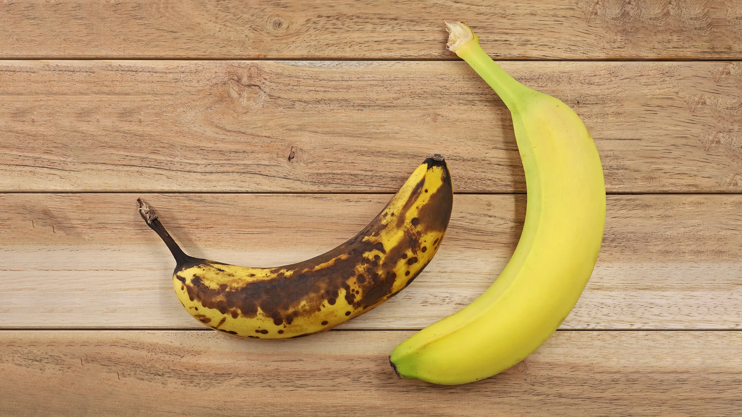 Açıq sarı banan daha yetişmiş qəhvəyi rəngli bananın yanında.