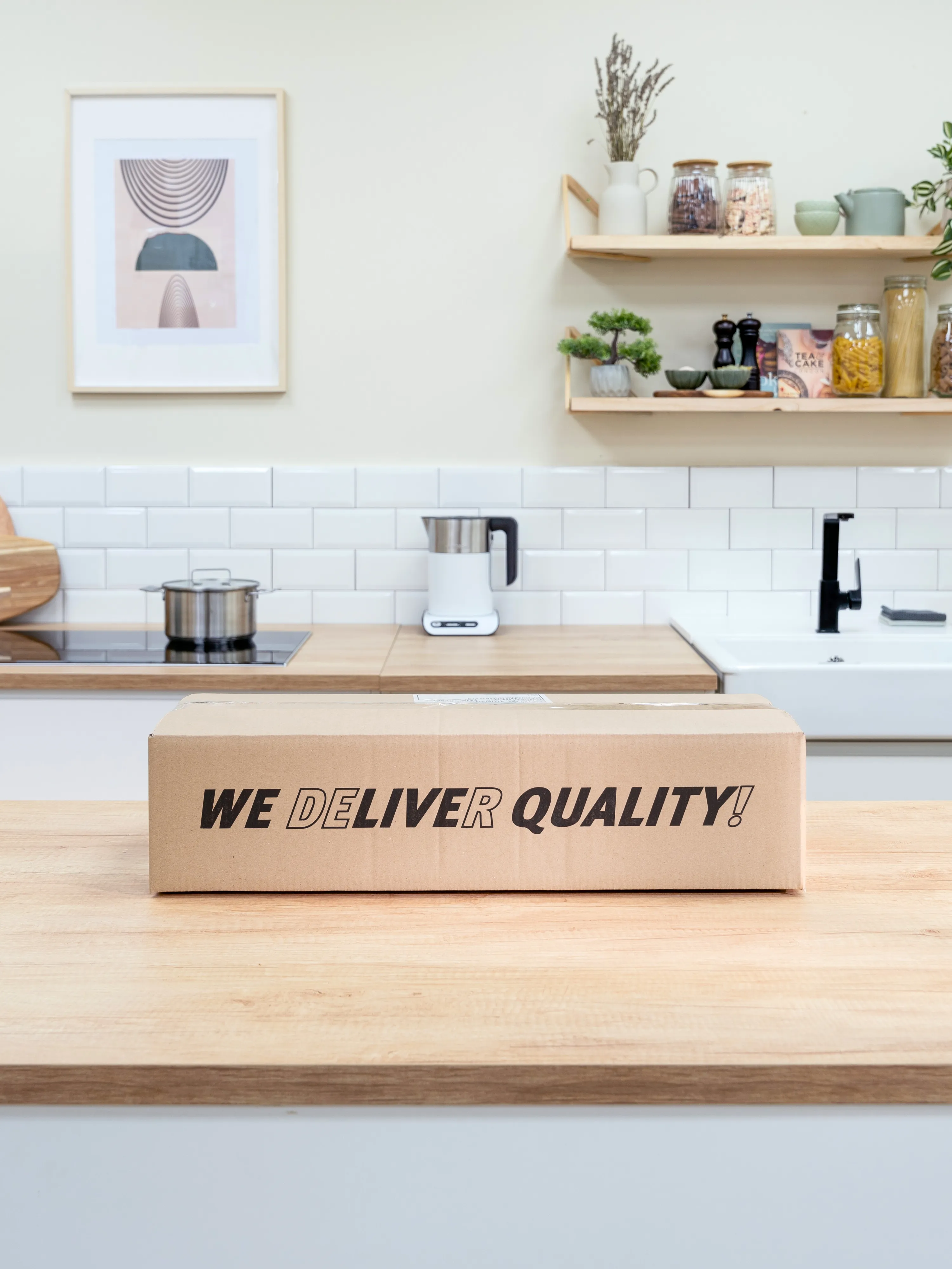 Comptoir de cuisine avec appareils, étagères, et une boîte en carton avec du texte de qualité "Nous live".