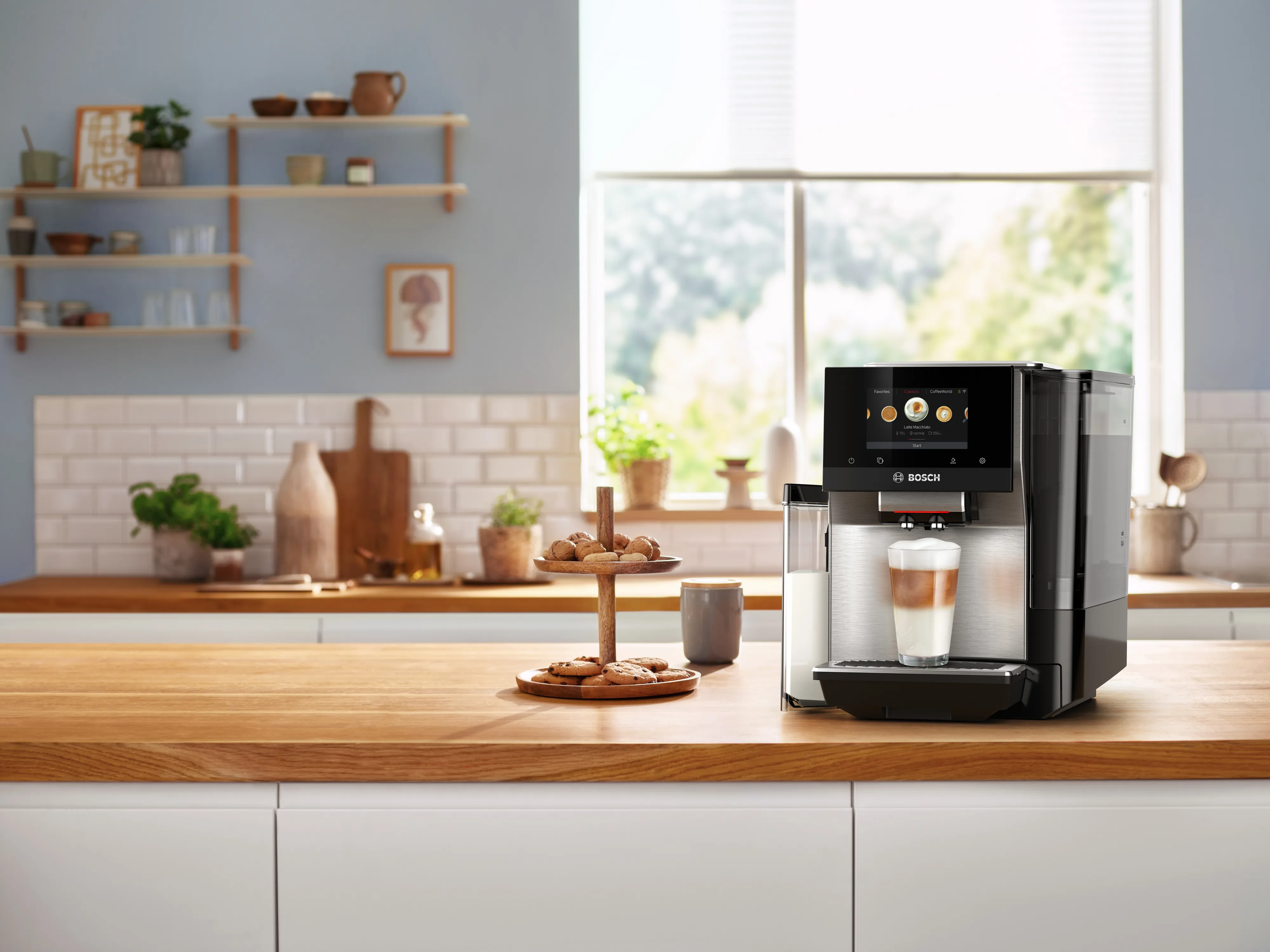 Bosch coffee machine on a wooden countertop in a bright kitchen with cookies nearby.