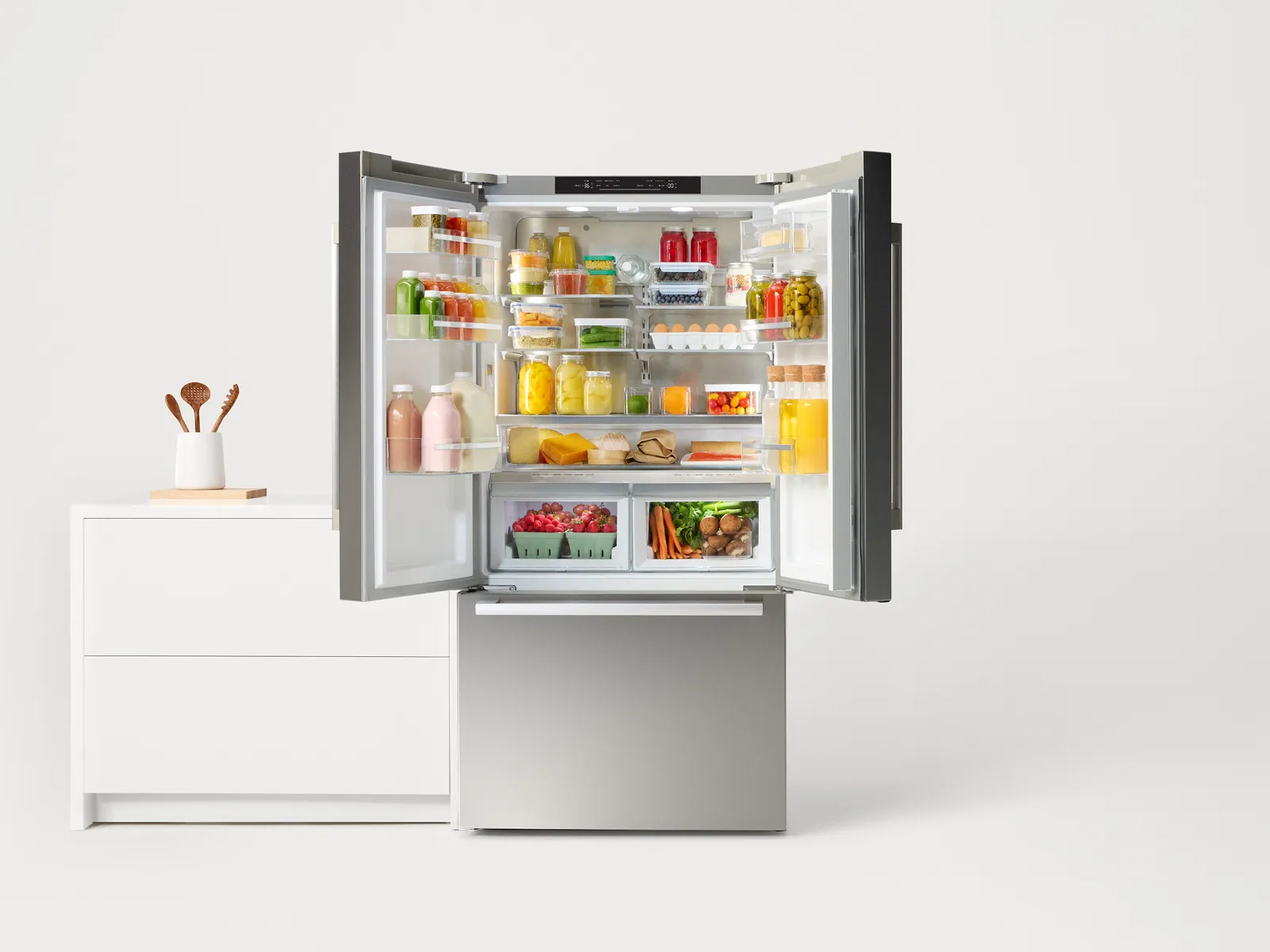 Bosch stainless steel refrigerator open filled with groceries and producess