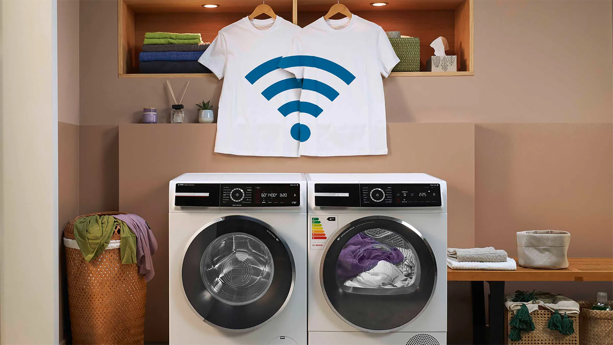 Vernetzte Bosch Waschmaschine und Trockner mit einem WLAN-Symbol auf aufgehängten T-Shirts.