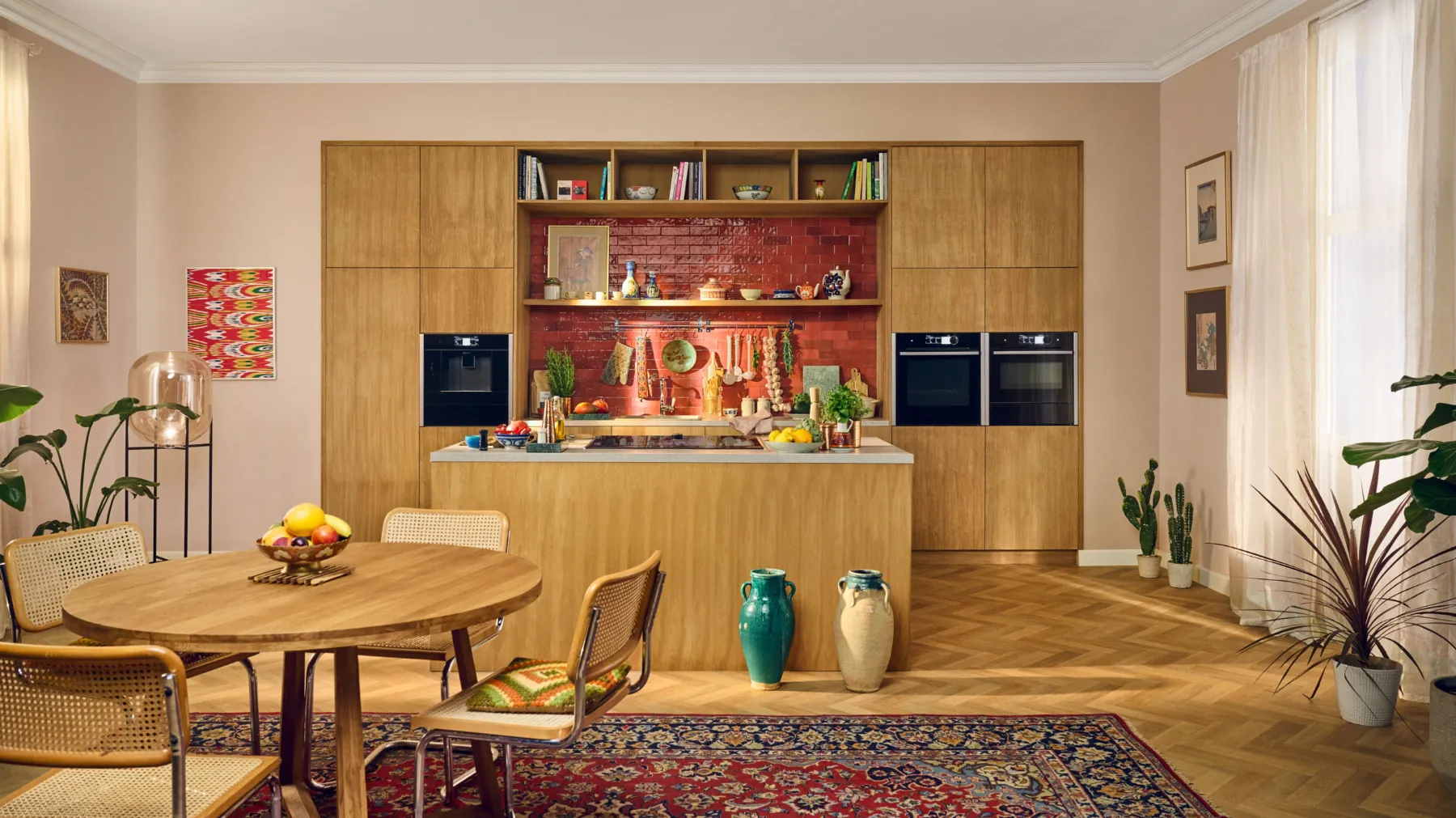 Spacious kitchen with wooden cabinets, dining table, and colourful decor elements.