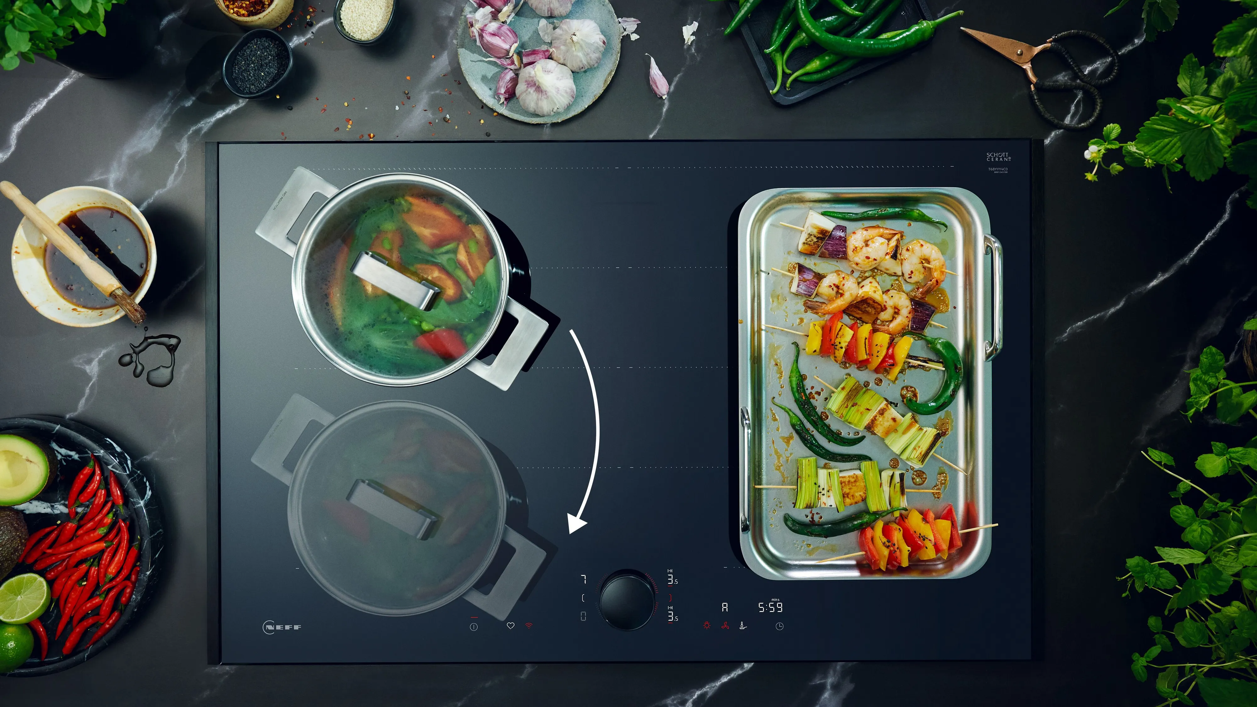 Moderne inductiekookplaat met twee pannen, kokende groenten en grillspiesjes, omringd door ingrediënten. 